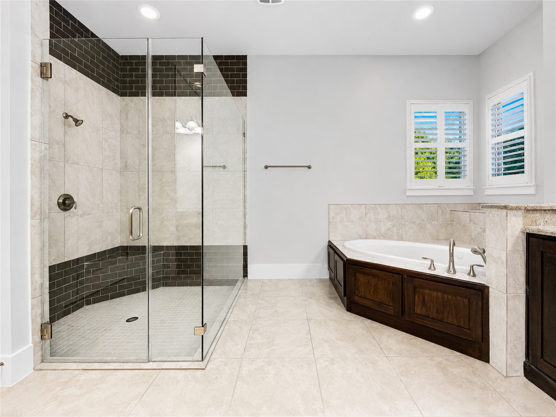 An oversized glass-enclosed walk-in shower and a tub create a private retreat designed for relaxation at the end of the day.
