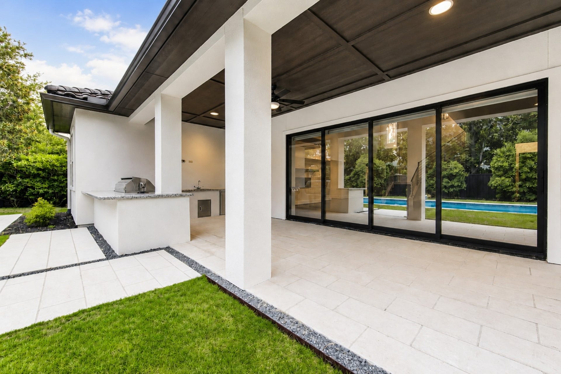 Expansive sliding doors seamlessly connect the main living areas to the covered patio, creating exceptional indoor-outdoor flow.