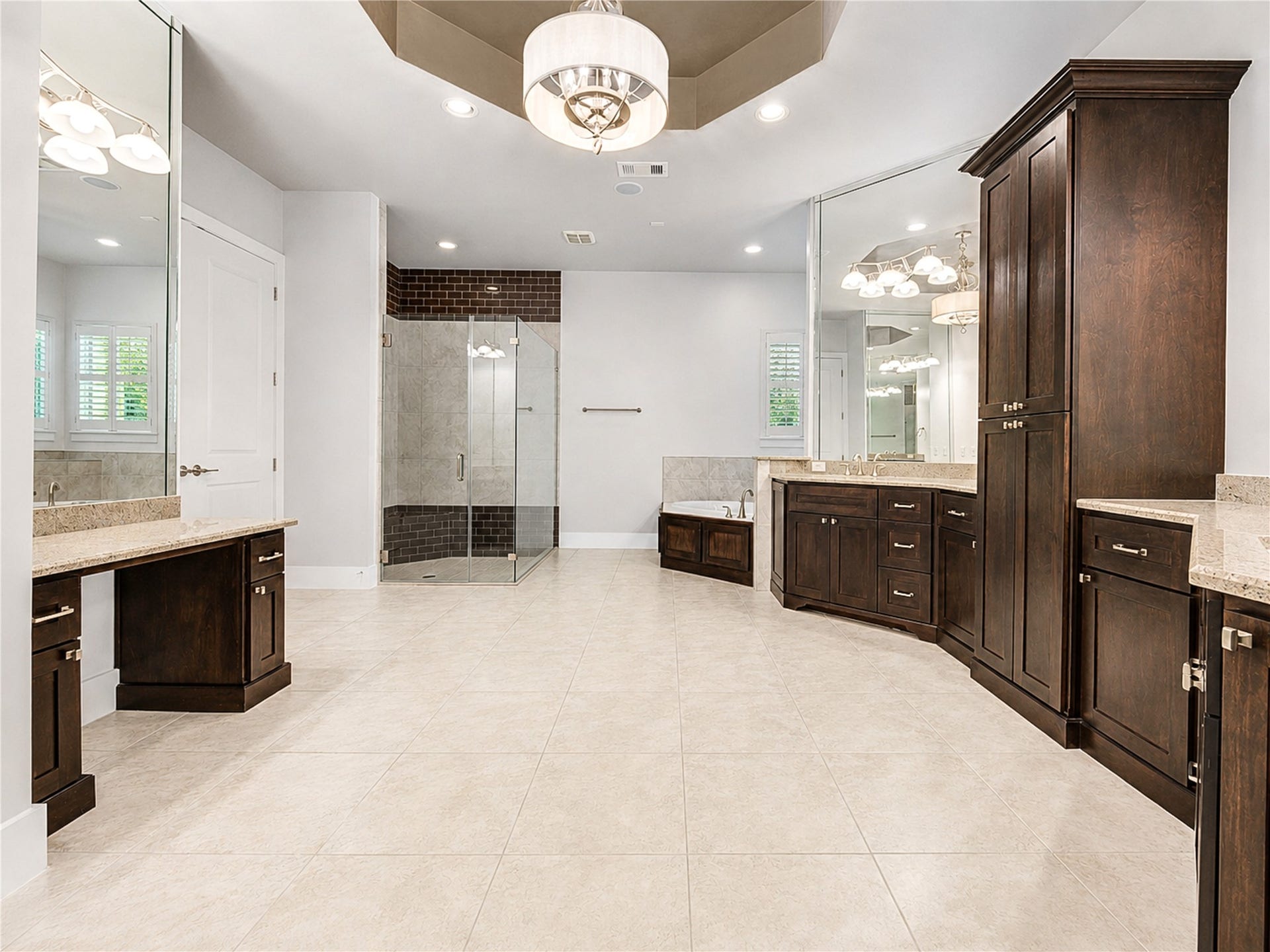 The impressively spacious primary bath features dual vanities, abundant cabinetry, a dedicated makeup area, an oversized walk-in shower and a relaxing spa tub.
