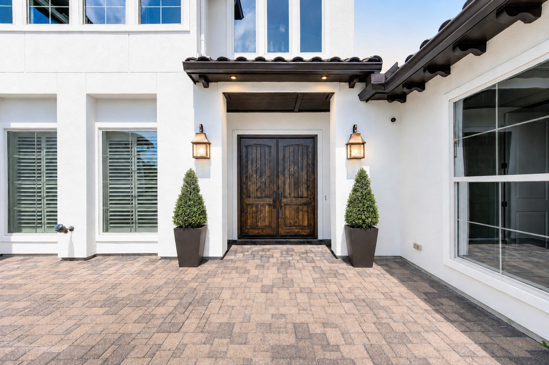 An inviting courtyard framed by Mediterranean-inspired architecture leads to impressive double entry doors, setting and elegant tone from the moment you arrive.