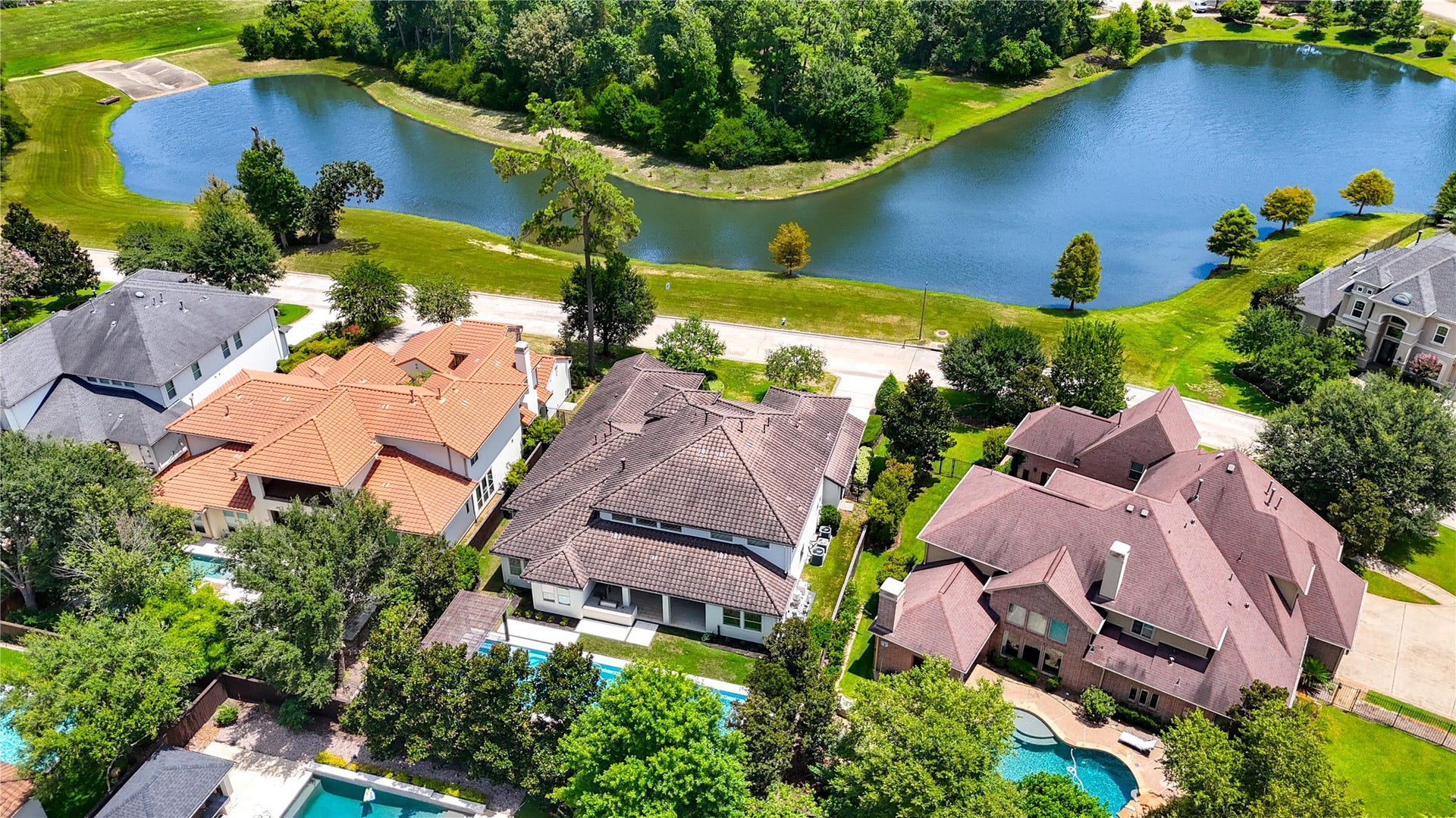 This aerial view showcases the home's coveted setting directly across from the lake, offering expansive water views with no homes to interrupt the scenery.