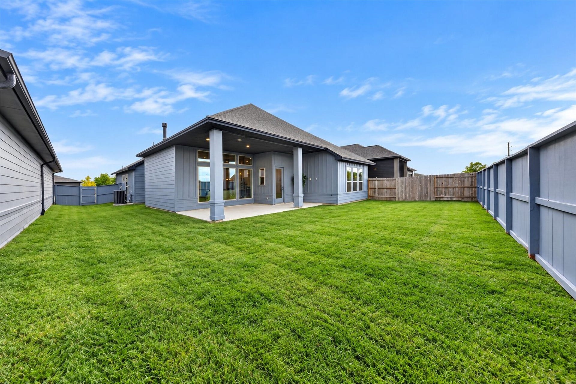 32510 Ebony Jewelwing Court, Fulshear, TX 77441 Backyard Wide backyard view featuring a spacious lawn, covered patio, privacy fencing, and plenty of room to create a personalized outdoor retreat.