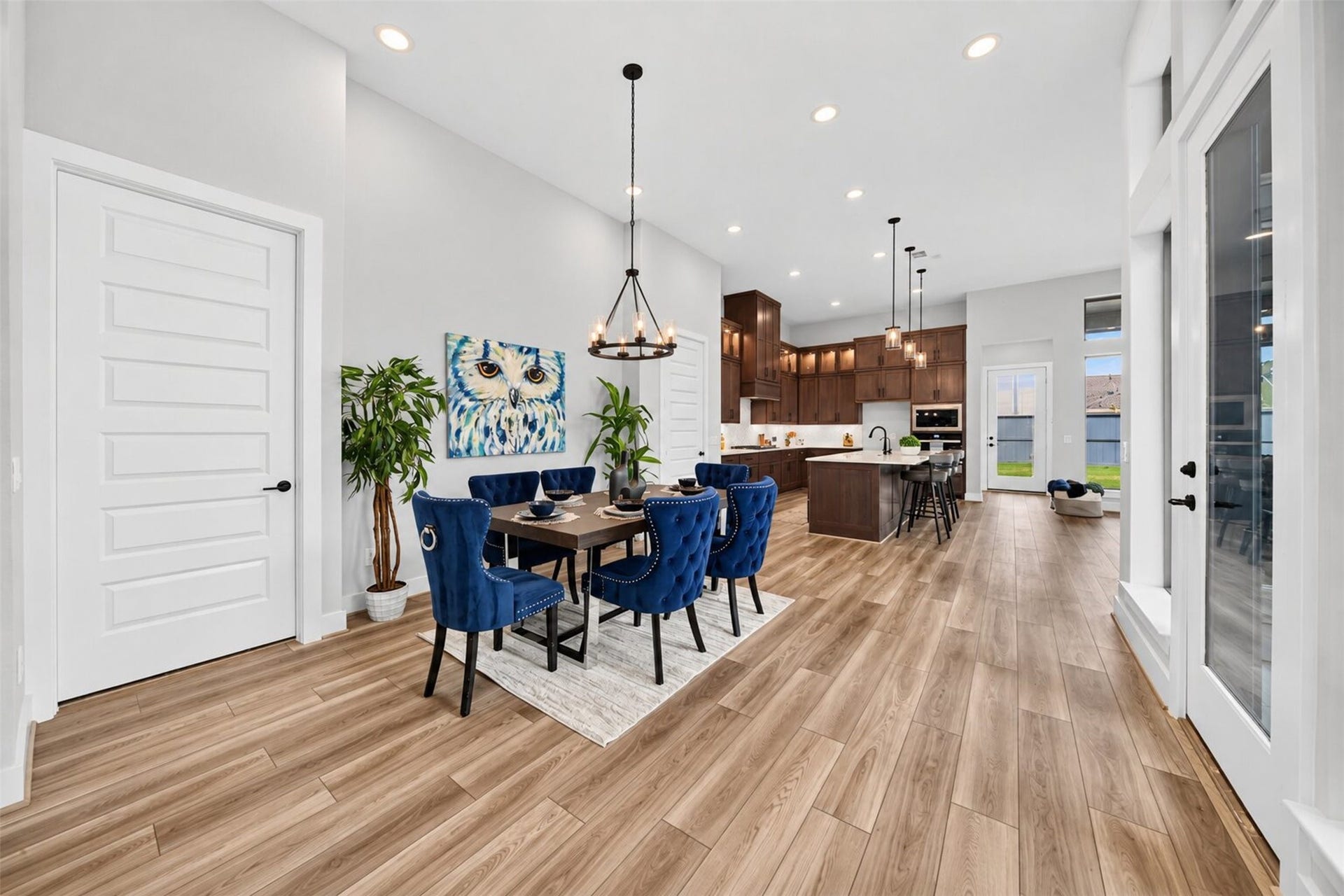 32510 Ebony Jewelwing Court, Fulshear, TX 77441 Dining & Kitchen: Open-concept dining area flows seamlessly into the kitchen, enhanced by high ceilings, abundant natural light, and warm wood-look flooring.