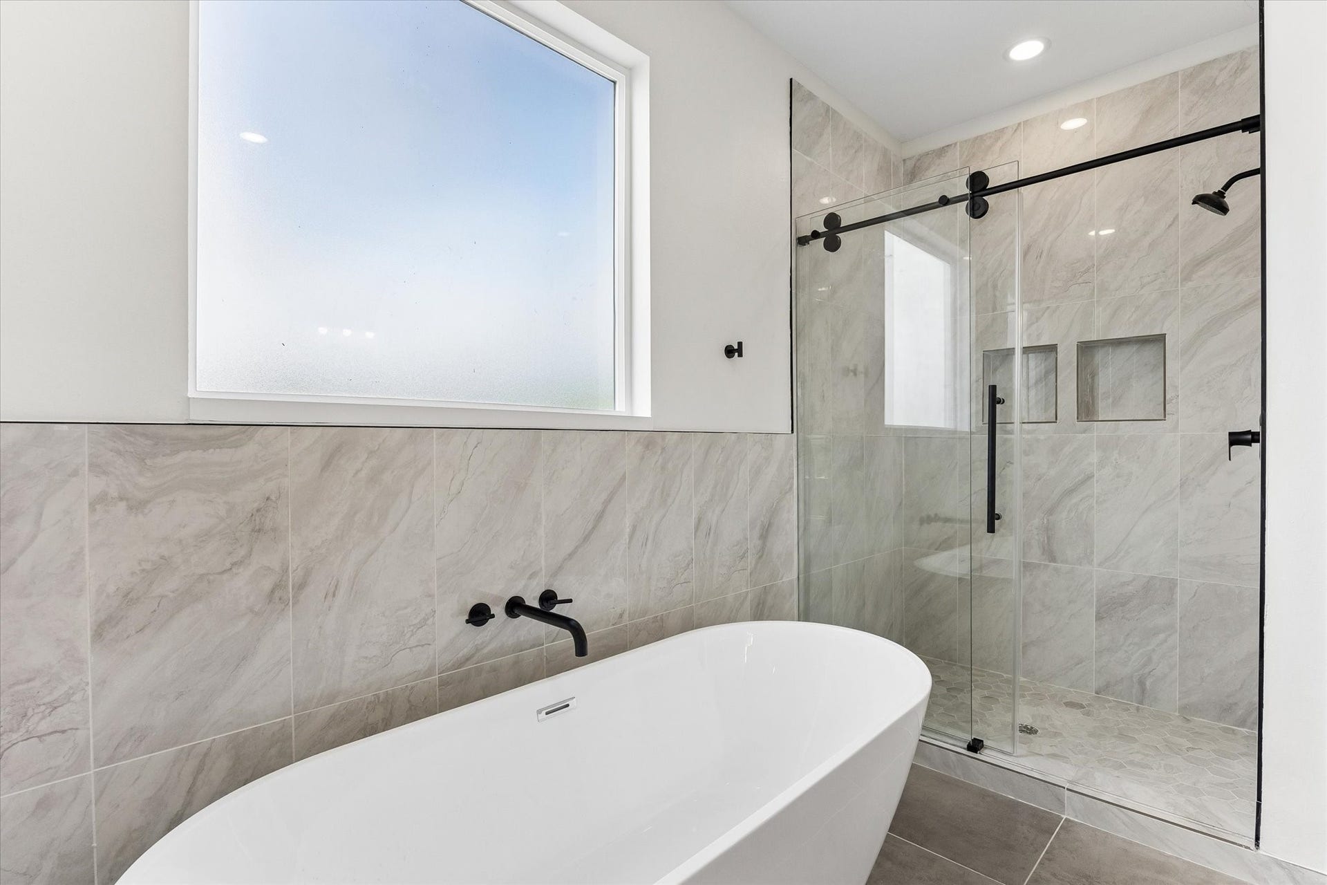 5106 Ricky Street, #A, Houston, TX 77033 Modern bath tub and large shower with seating.