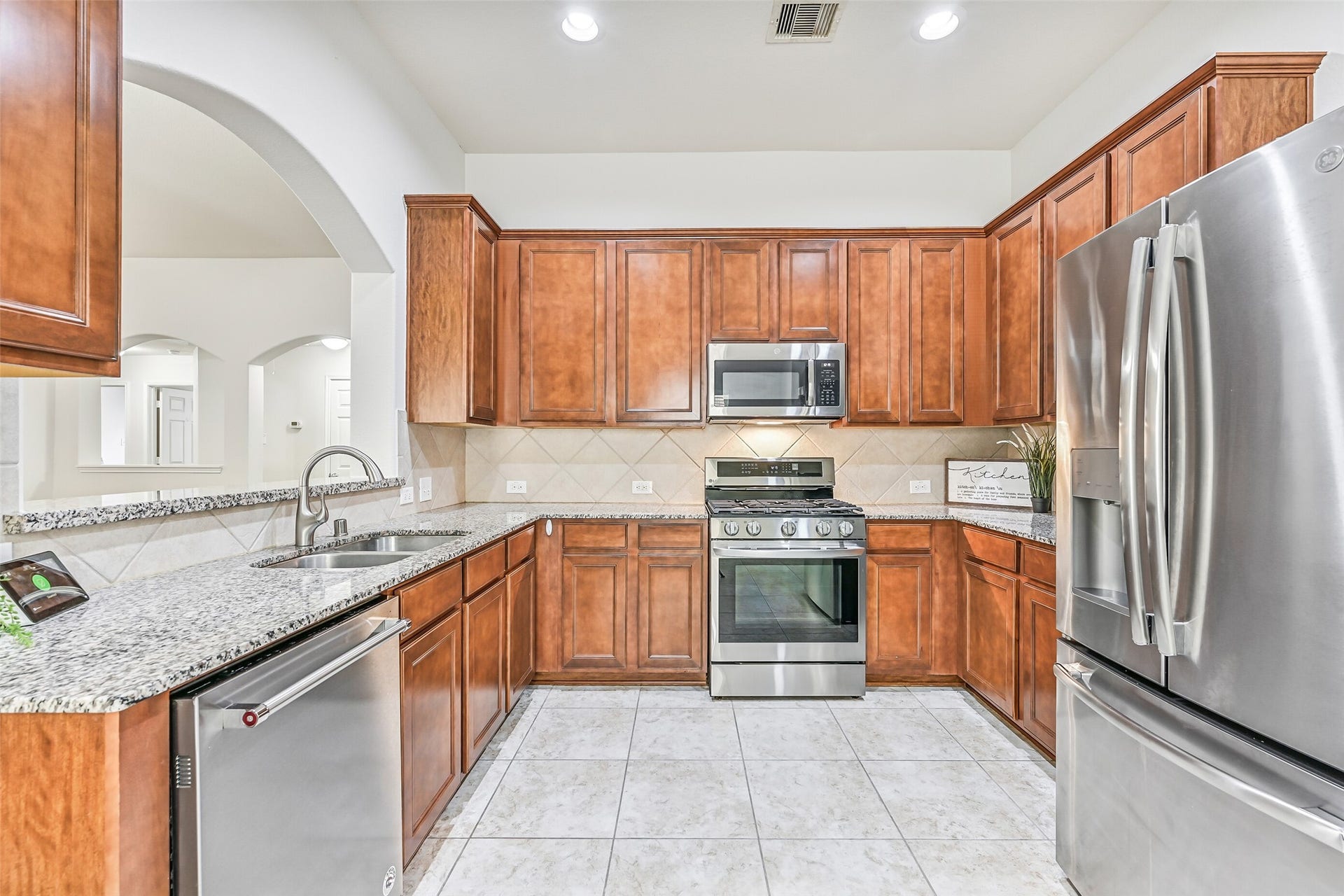 318 Lake Line Drive, Alvin, TX 77511 The kitchen offers an impressive amount of cabinetry and counter space, with granite surfaces wrapping around the room, stainless appliances, recessed lighting and an open sightline into the family room.