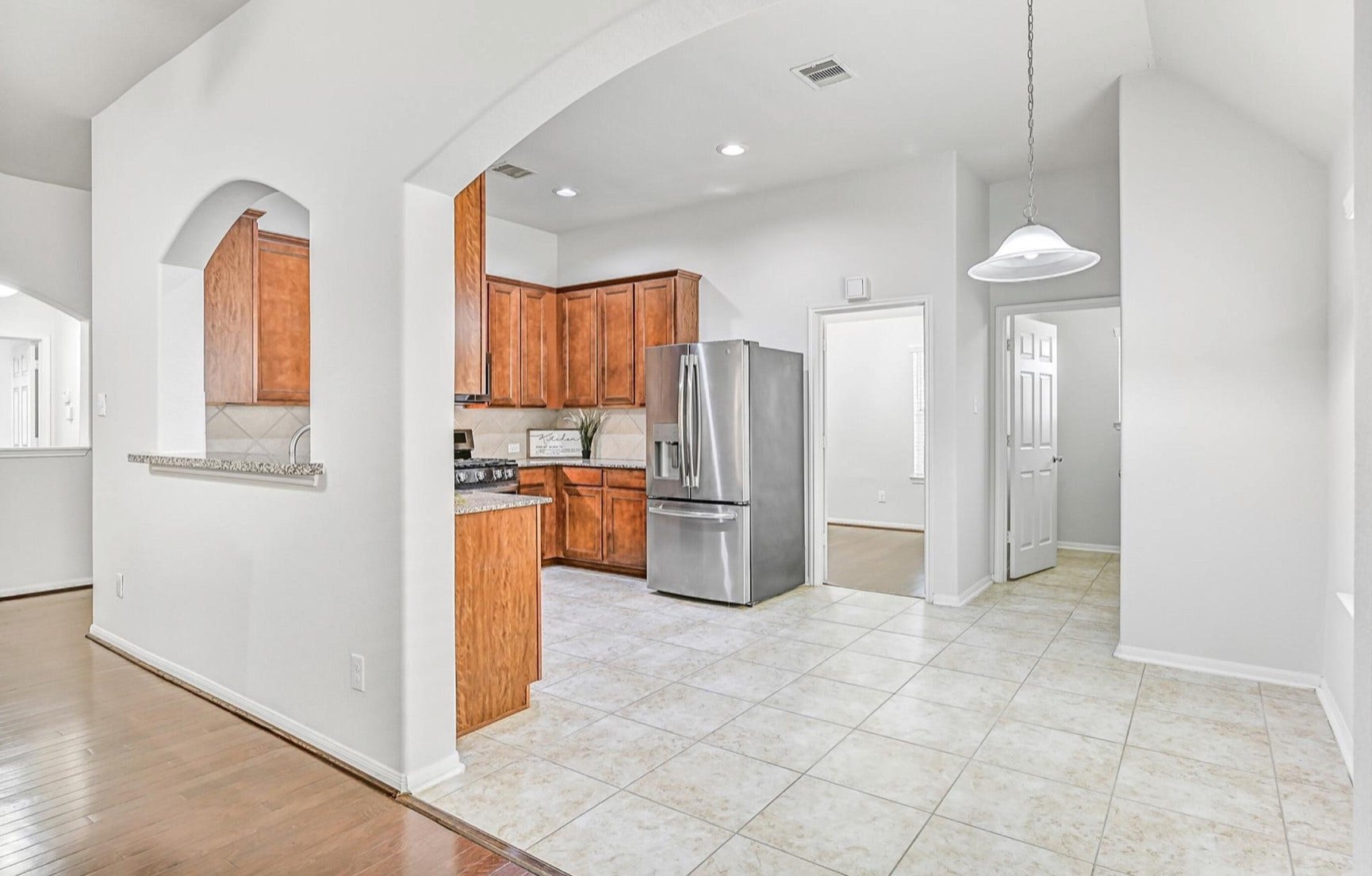318 Lake Line Drive, Alvin, TX 77511 An oversized arched opening introduces the bright breakfast area, conveniently positioned alongside the kitchen and family room with easy-care tile flooring, pendant lighting and plenty of space for a casual dining table.