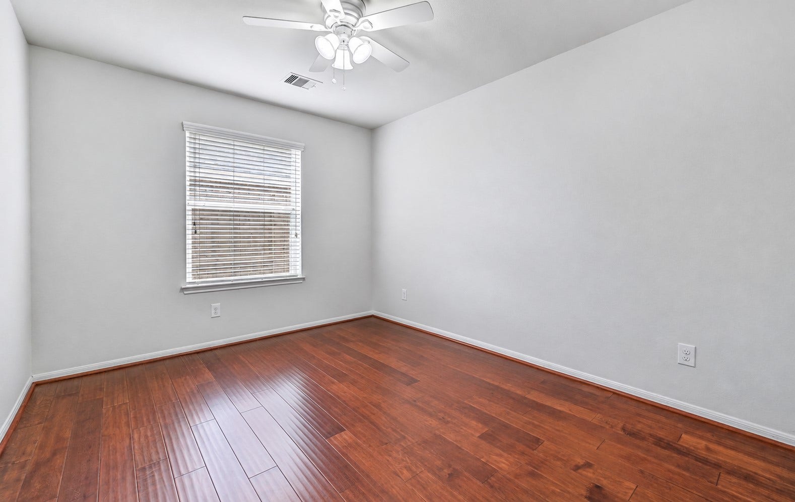 318 Lake Line Drive, Alvin, TX 77511 A second secondary bedroom features wood flooring, fresh neutral paint, a ceiling fan & large window with 2" blinds, offering comfortable proportions and plenty of flexibility for family, guests or hobbies.