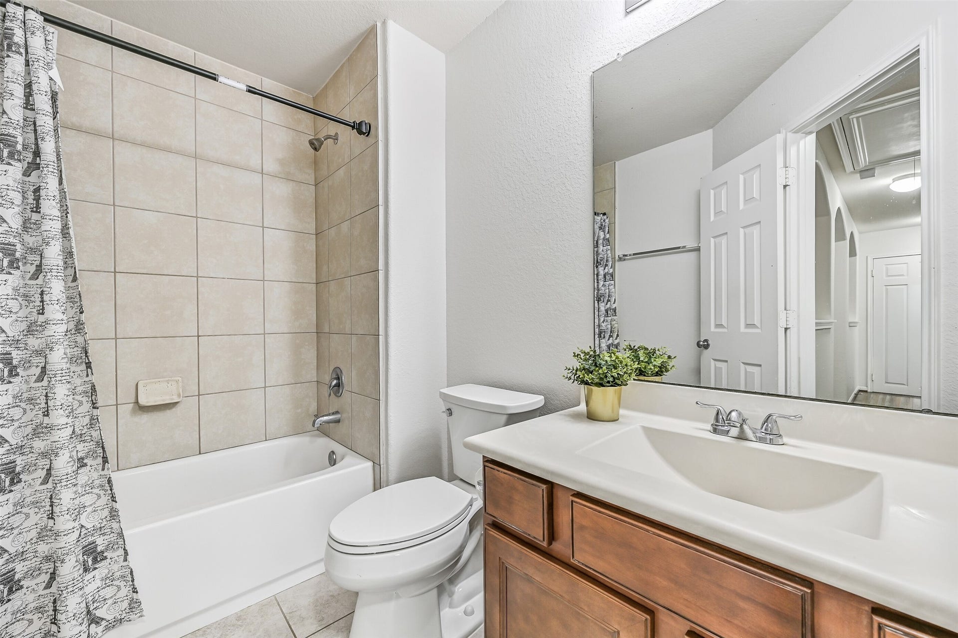 318 Lake Line Drive, Alvin, TX 77511 The secondary bedrooms share this well-maintained hall bath featuring tile flooring, a tub/shower combination with full-height tile surround, spacious vanity with storage & an oversized wall mirror.