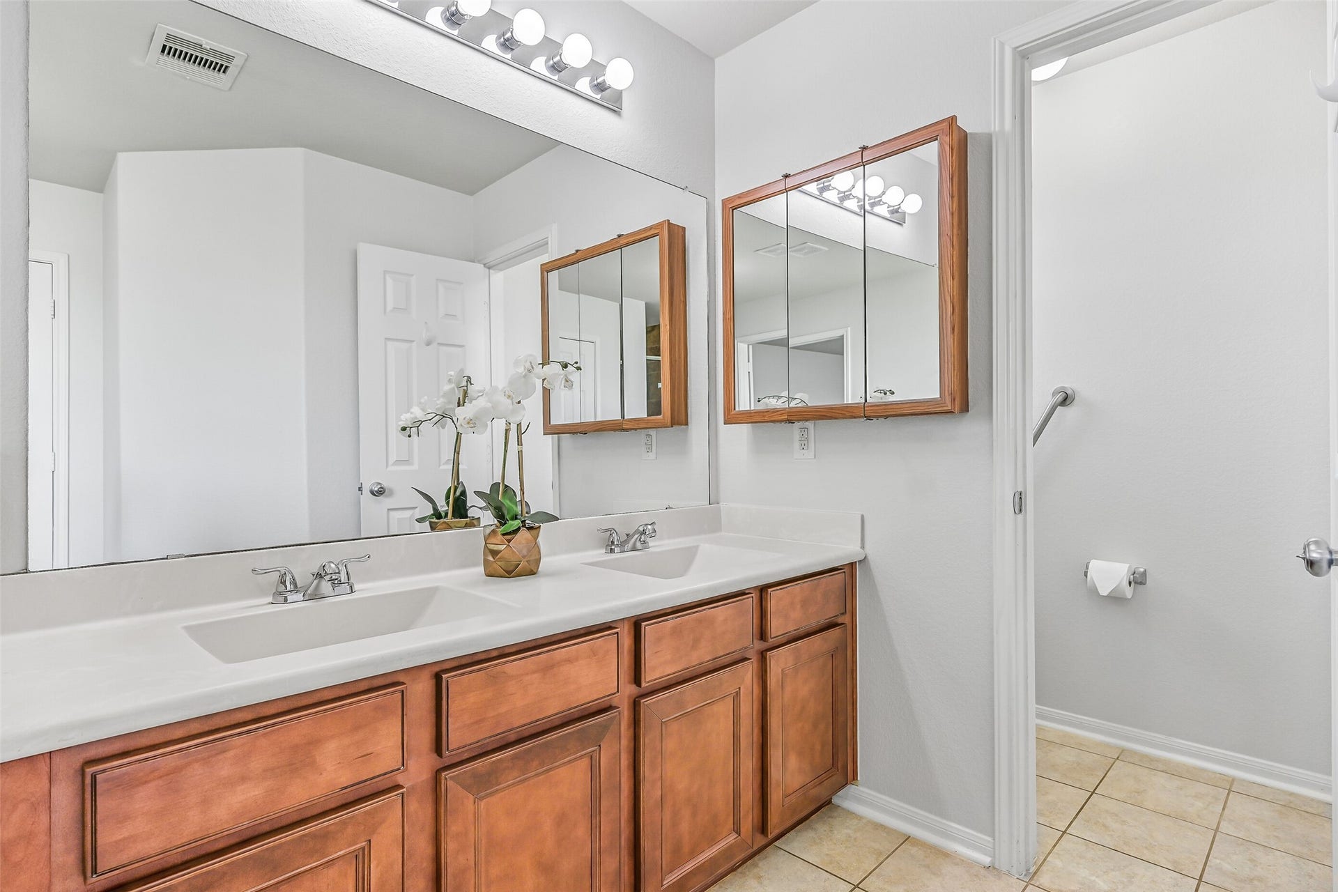 318 Lake Line Drive, Alvin, TX 77511 A long dual-sink vanity provides plenty of counter space and storage in the primary bath, complemented by a wall-spanning mirror and convenient access to the separate shower and walk-in closet.