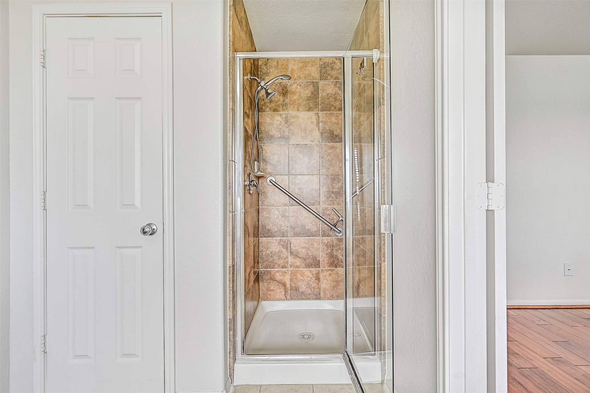 318 Lake Line Drive, Alvin, TX 77511 The primary bath also features a separate tile-surround shower with glass enclosure, handheld showerhead & grab bar, positioned alongside the walk-in closet for a practical and well-designed en-suite layout.