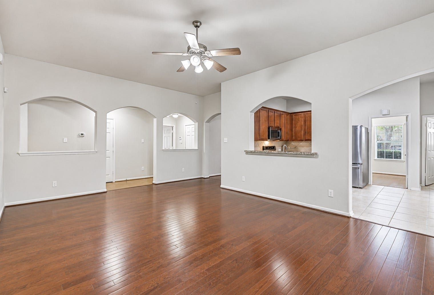 318 Lake Line Drive, Alvin, TX 77511 From this angle, the family room highlights the home's easy flow, with arched openings and a granite-topped pass-through providing an open connection to the kitchen, breakfast area and surrounding living spaces.
