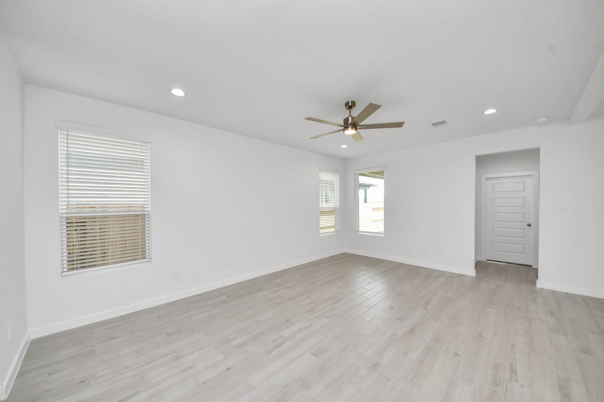 Family room flooded with natural light through the expansive windows.  The premium tile flooring adds a touch of luxury to the space, creating the perfect setting for relaxing moments and cherished gatherings with loved ones. Sample photo of completed home with similar floor plan. Actual colors and selections may vary.