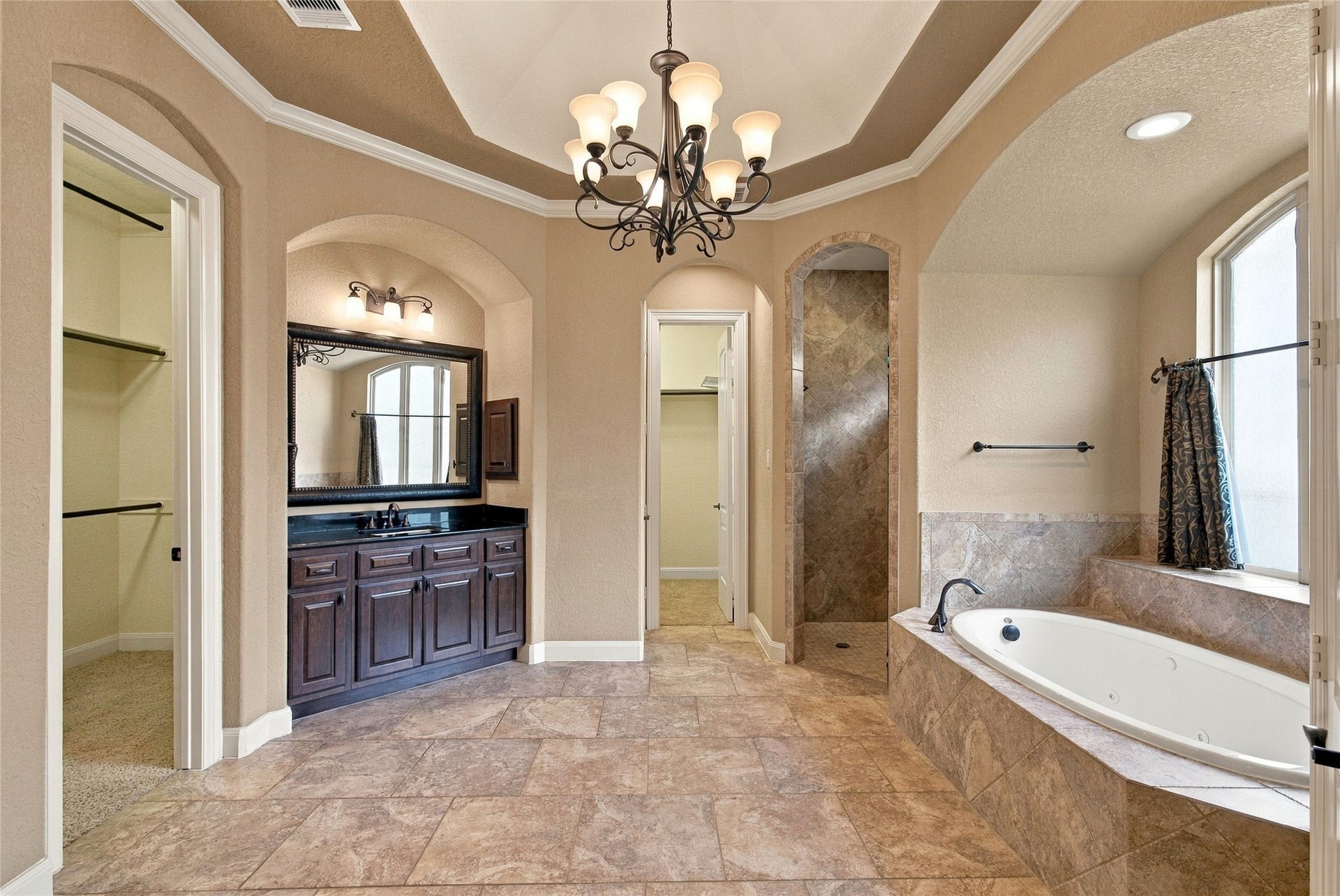 19215 Shady Blossom Drive, Cypress, TX 77433 Luxurious primary bathroom featuring an oversized jetted soaking tub, separate walk-in shower, and beautiful architectural details.