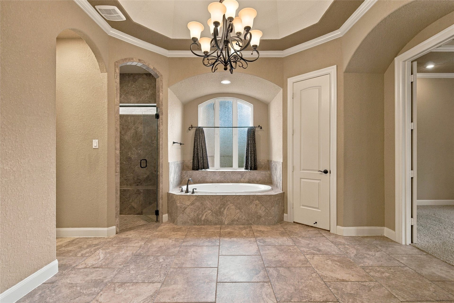 19215 Shady Blossom Drive, Cypress, TX 77433 Another view of the primary bathroom showcasing the beautiful soaking tub, chandelier, and elegant architectural accents.