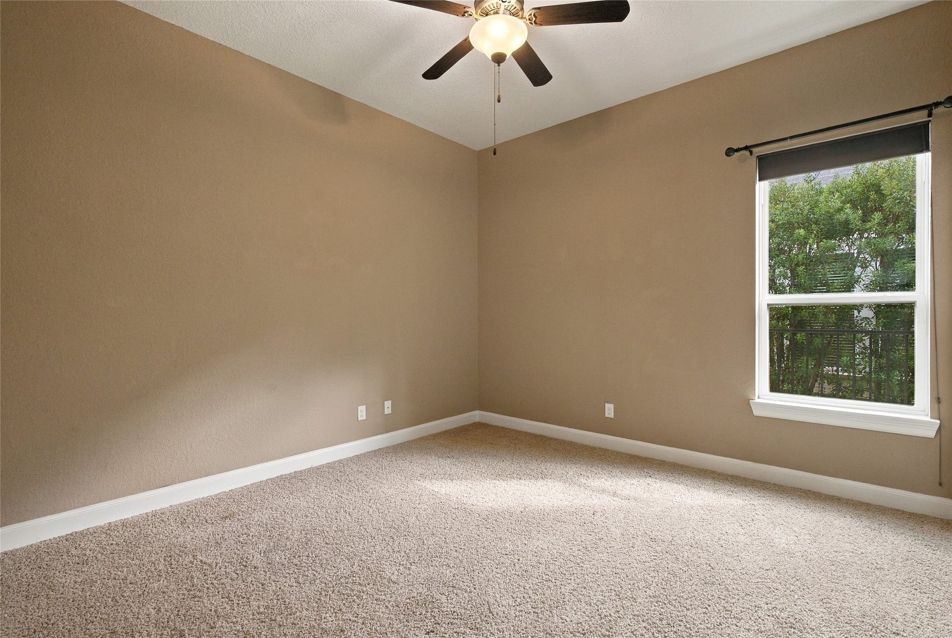 19215 Shady Blossom Drive, Cypress, TX 77433 Comfortable secondary bedroom featuring plush carpeting, a window overlooking the outdoors, and a private bathroom.