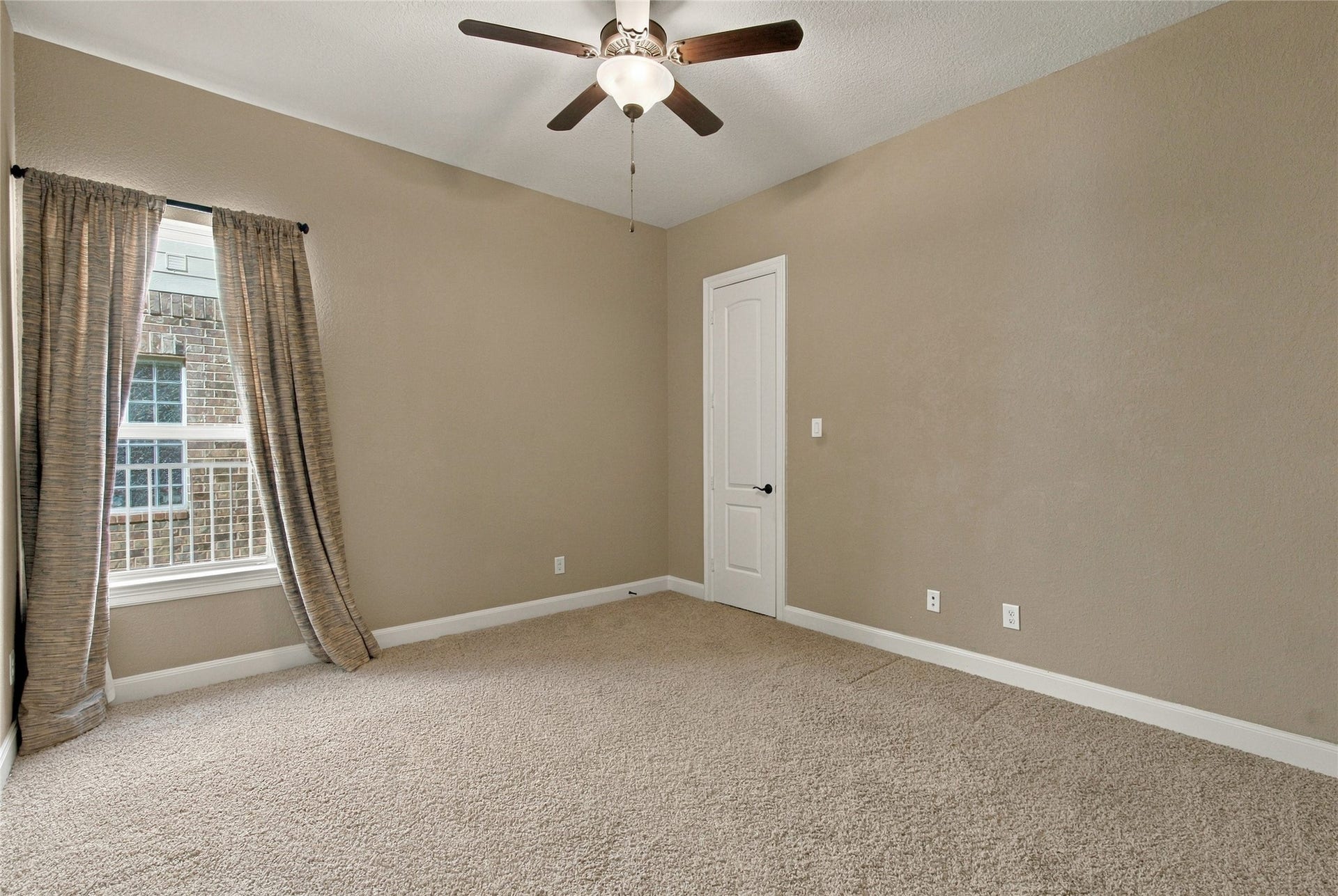 19215 Shady Blossom Drive, Cypress, TX 77433 Spacious secondary bedroom featuring plush carpeting, a walk-in closet, and a large window allowing natural light to fill the space.