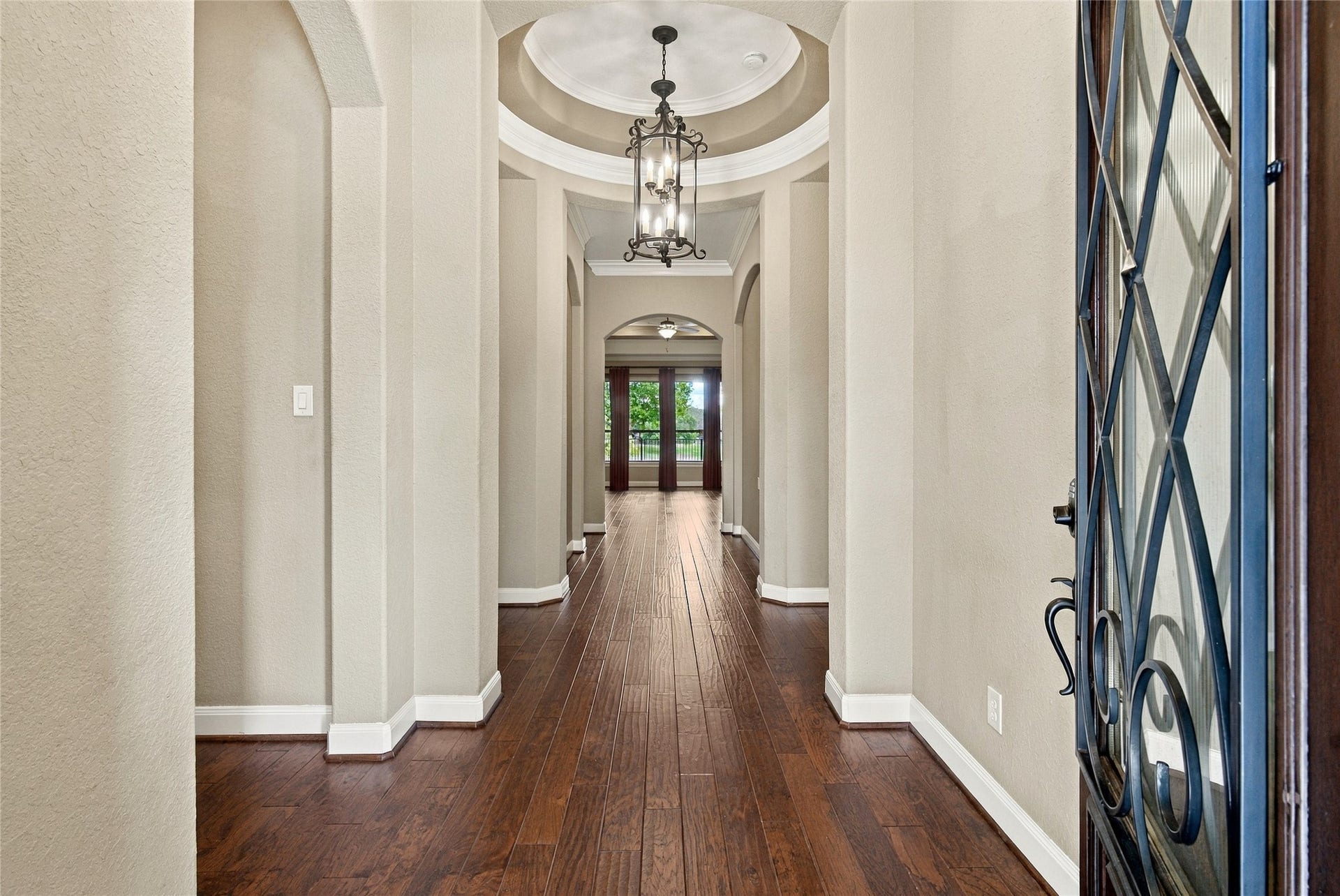 19215 Shady Blossom Drive, Cypress, TX 77433 Elegant entryway featuring wood flooring, high ceilings, beautiful architectural details, and a stylish chandelier.