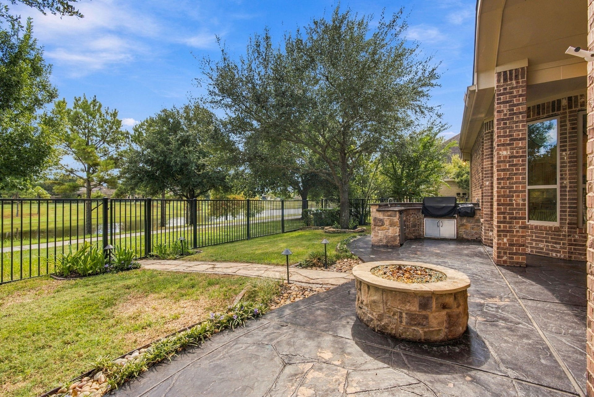 19215 Shady Blossom Drive, Cypress, TX 77433 Stone gas fire pit offering the perfect spot to relax while enjoying peaceful water views.
