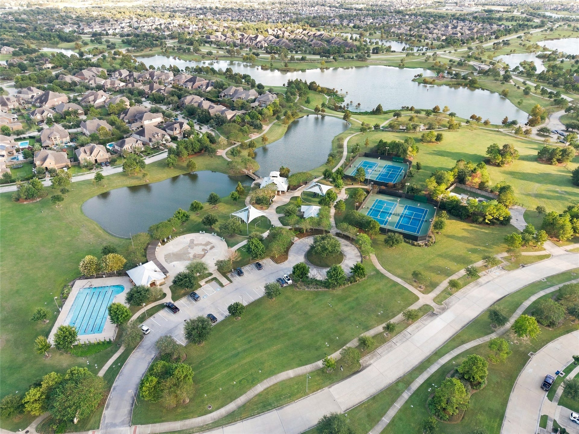 19215 Shady Blossom Drive, Cypress, TX 77433 Aerial view highlighting the community's recreational amenities, beautiful green spaces, and picturesque waterfront surroundings.