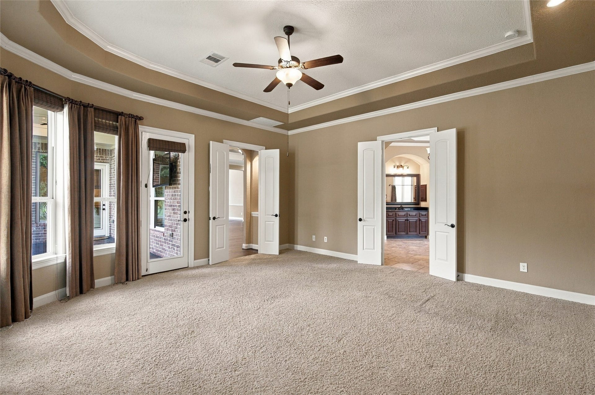 19215 Shady Blossom Drive, Cypress, TX 77433 Another view of the inviting primary retreat, offering generous space, abundant natural light, and direct access to the covered patio.