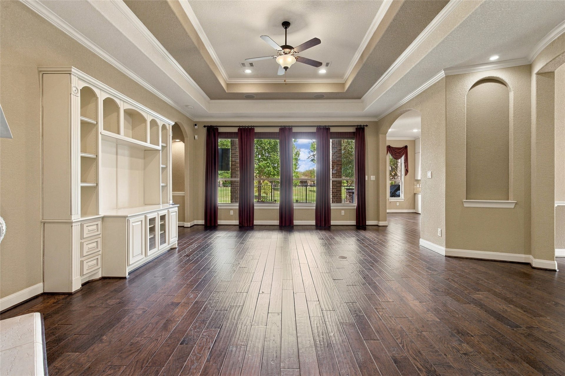 19215 Shady Blossom Drive, Cypress, TX 77433 Another view of the inviting living room showcasing the open layout, decorative ceiling details, and large windows overlooking the backyard.