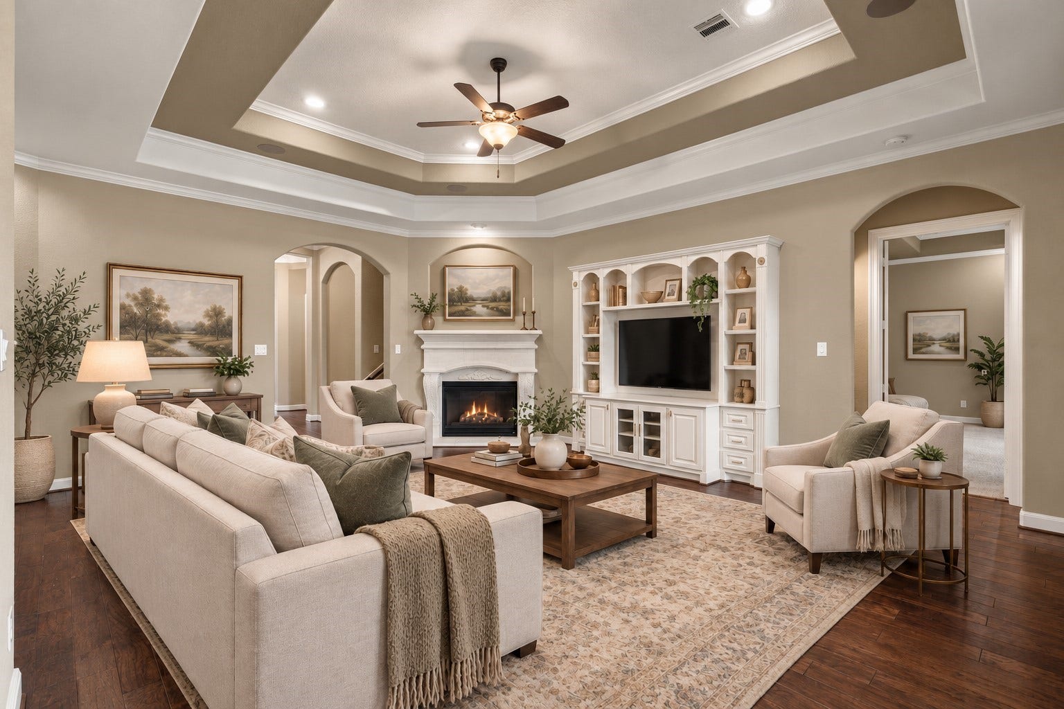 19215 Shady Blossom Drive, Cypress, TX 77433 Spacious living room featuring beautiful wood flooring, a fireplace, custom built-ins, and an elegant tray ceiling. (Virtually Staged)