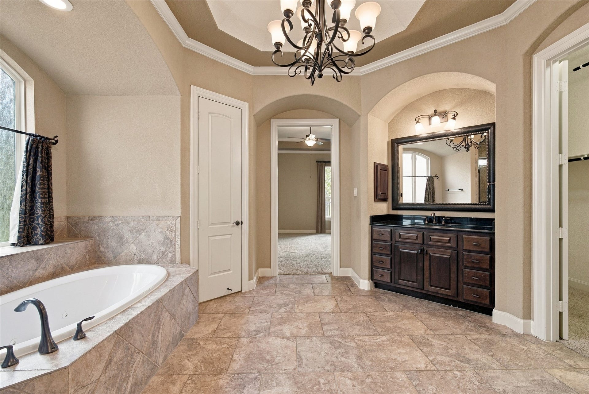 19215 Shady Blossom Drive, Cypress, TX 77433 Enjoy a relaxing retreat in the spacious primary bathroom featuring an oversized jetted tub, separate shower, and beautiful chandelier.