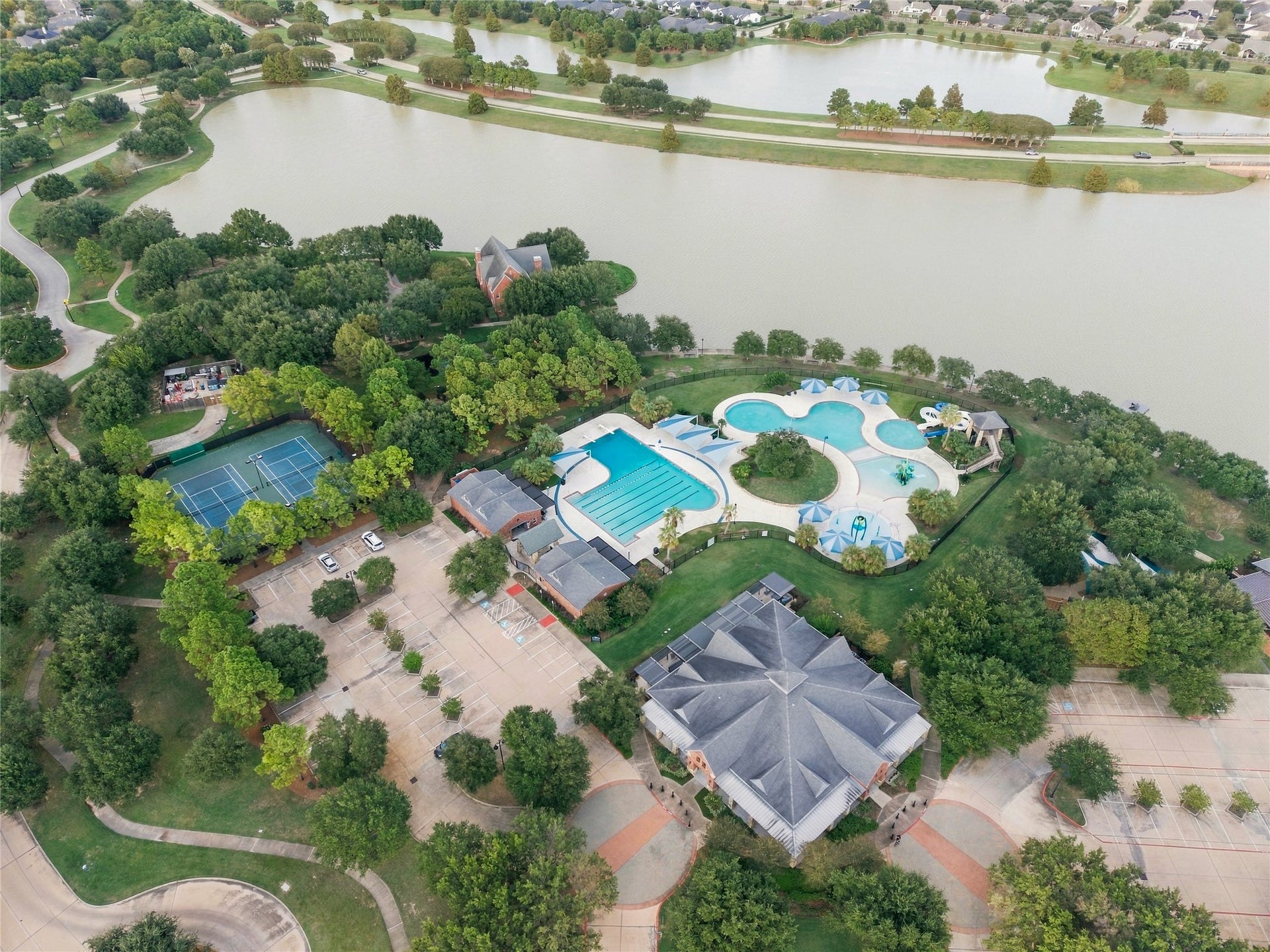 19215 Shady Blossom Drive, Cypress, TX 77433 Aerial view highlighting another Bridgeland community center with pools, tennis courts, and a gorgeous lake.