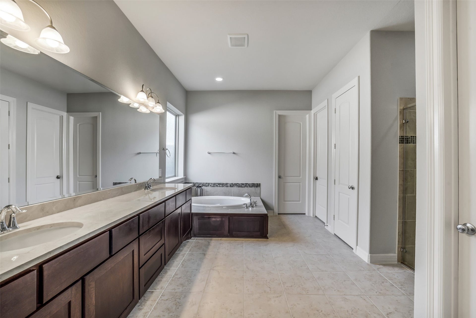 2721 Saddlehorn Trail, Katy, TX 77494 This spa-like ensuite features dual vanities, a soaking tub, separate shower, and elegant finishes throughout. Enjoy the convenience of TWO generously sized walk-in closets offering abundance of storage and organization.