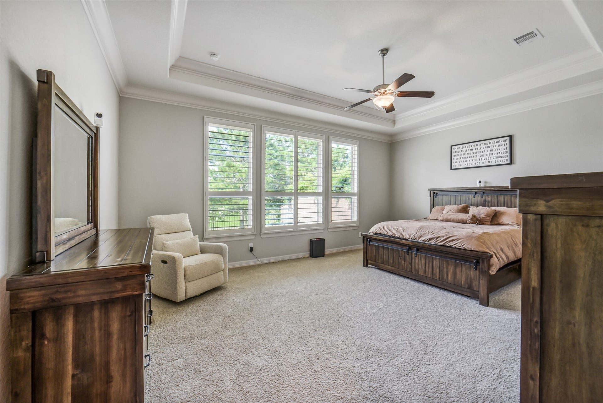 2721 Saddlehorn Trail, Katy, TX 77494 Retreat to this spacious primary suite featuring elegant tray ceilings, oversized windows with plantation shutters, plush pristine carpet, and a peaceful sitting area filled with natural light.