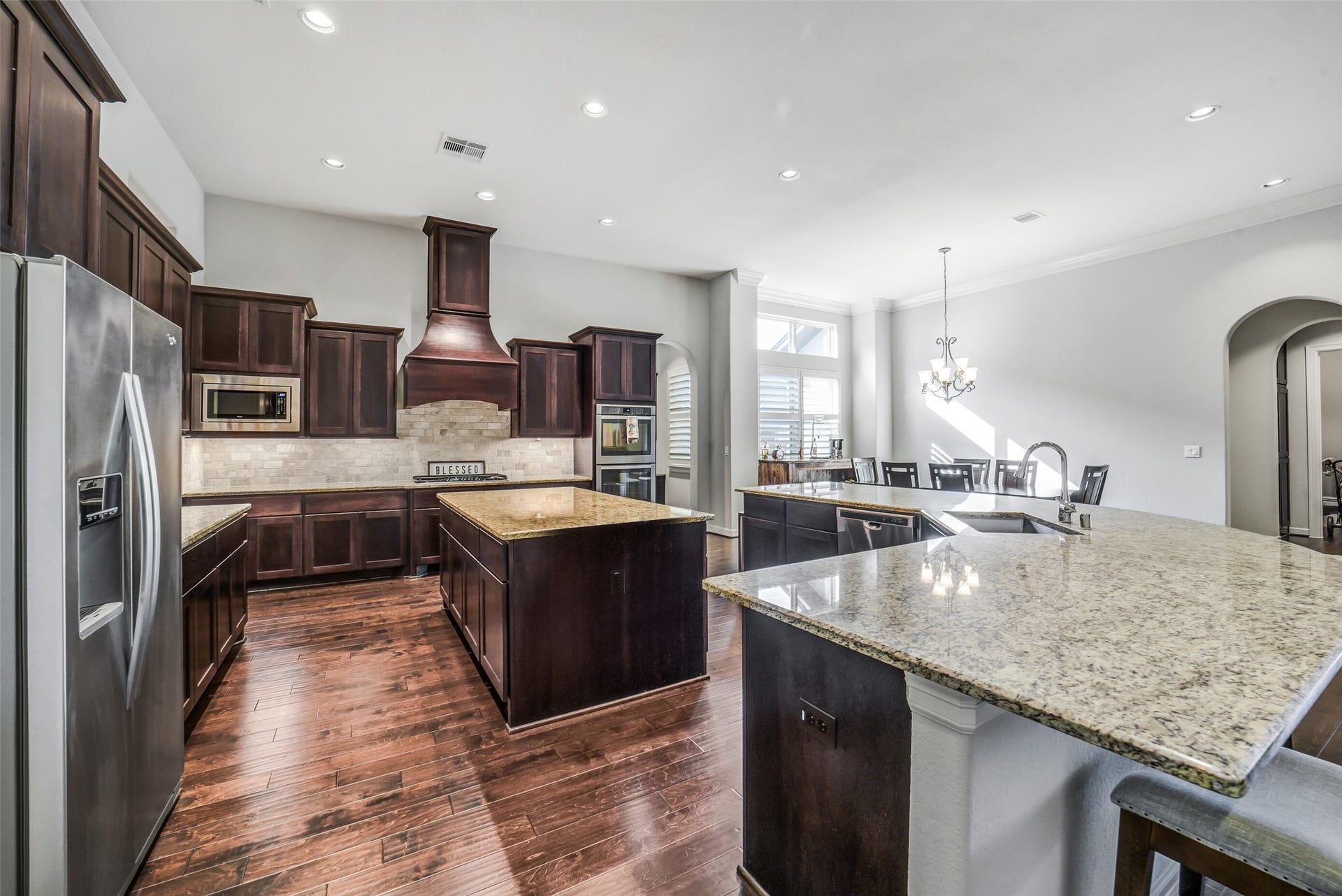 2721 Saddlehorn Trail, Katy, TX 77494 Gourmet kitchen designed for entertaining, featuring rich custom cabinetry, granite countertops, double island, stainless steel appliances, an abundance of prep space, and an open layout that flows seamlessly into the dining and living areas.