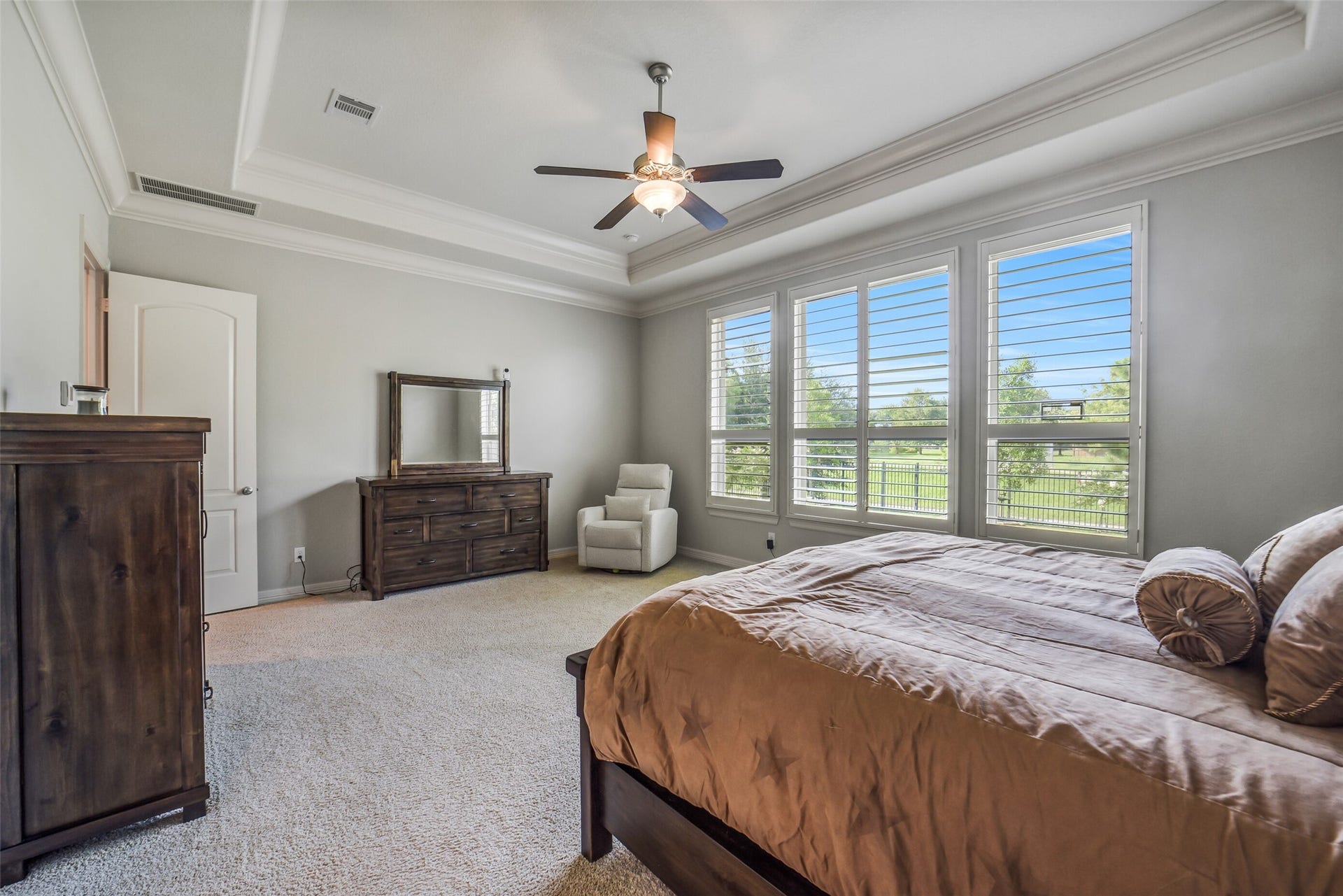 2721 Saddlehorn Trail, Katy, TX 77494 This luxurious primary suite offers a relaxing retreat with soaring tray ceilings, oversized windows, and plenty of room for a sitting area.