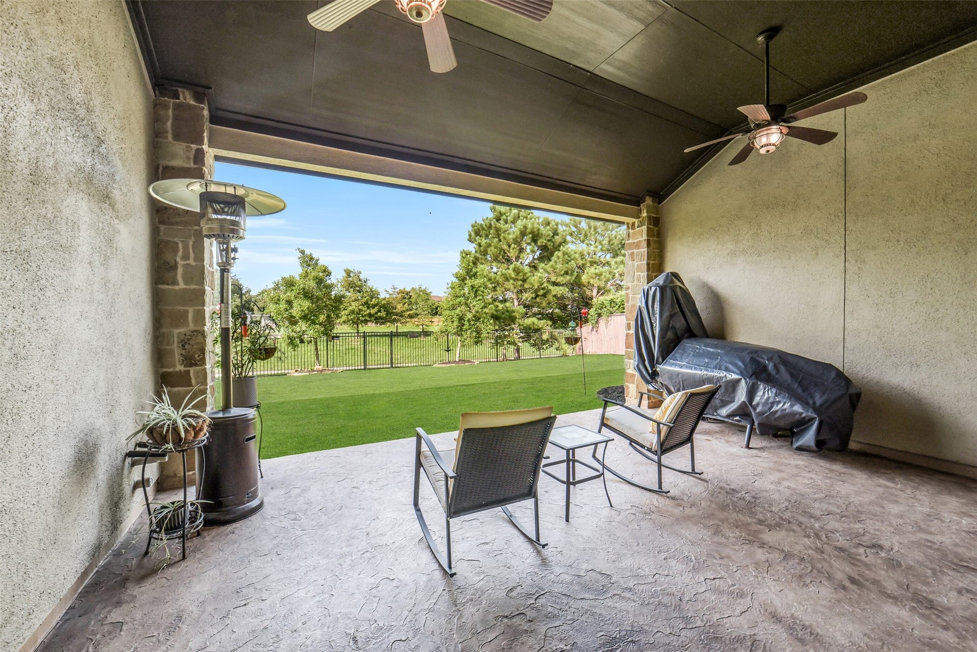 2721 Saddlehorn Trail, Katy, TX 77494 Relax year round on the spacious covered patio featuring dual ceiling fans, plenty of room for outdoor dining and entertaining, and peaceful views of the beautifully maintained backyard.