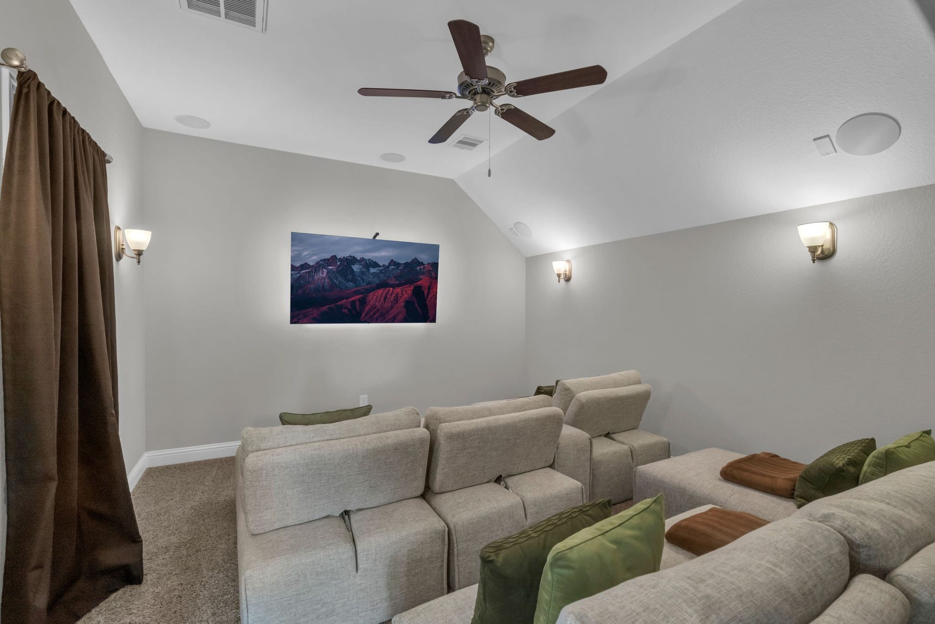 Amazing media room with built-in speakers, access to the attic with storage space, and plenty of space for movie nights.