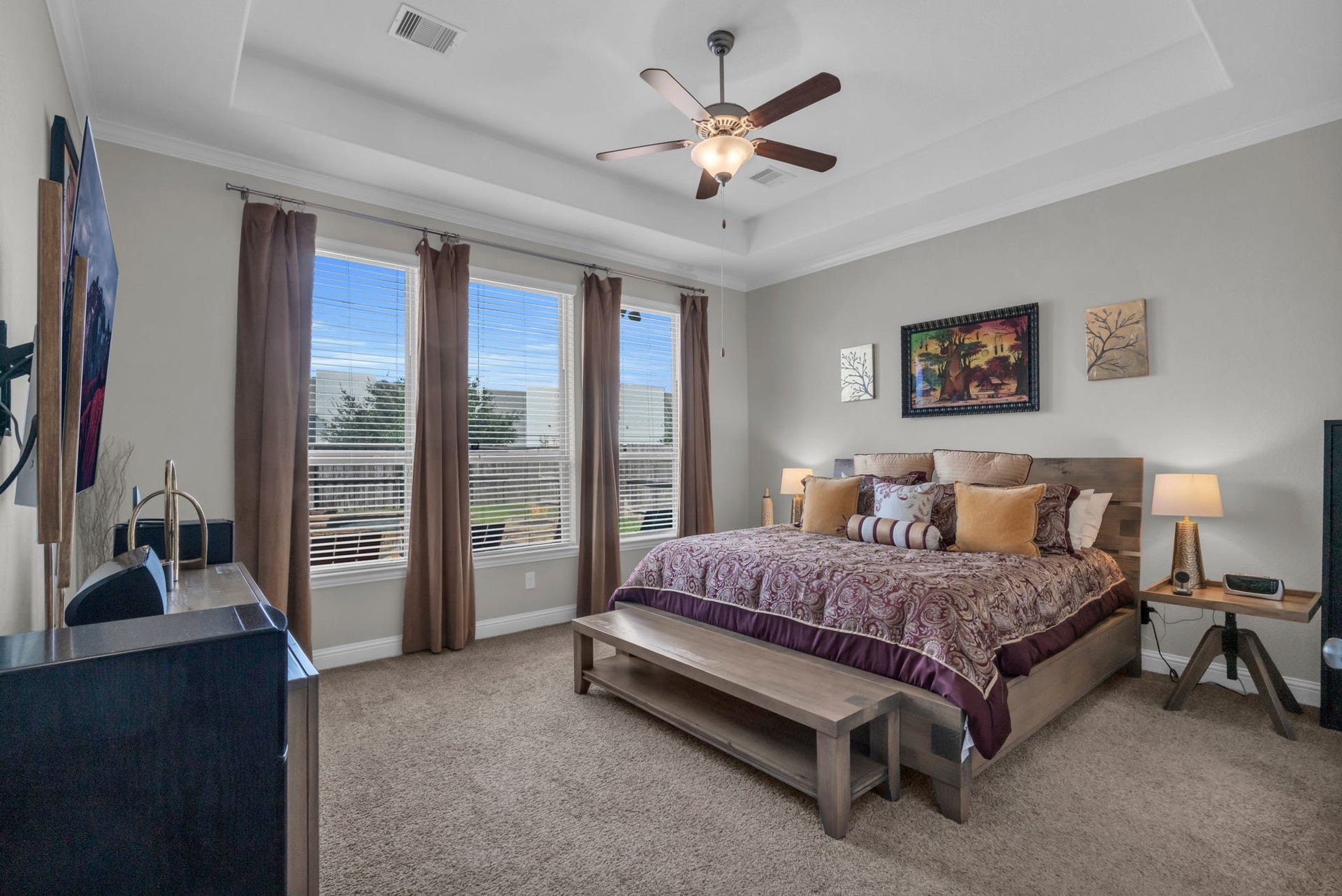 Secluded downstairs primary bedroom with vaulted ceilings and overlooks the backyard.