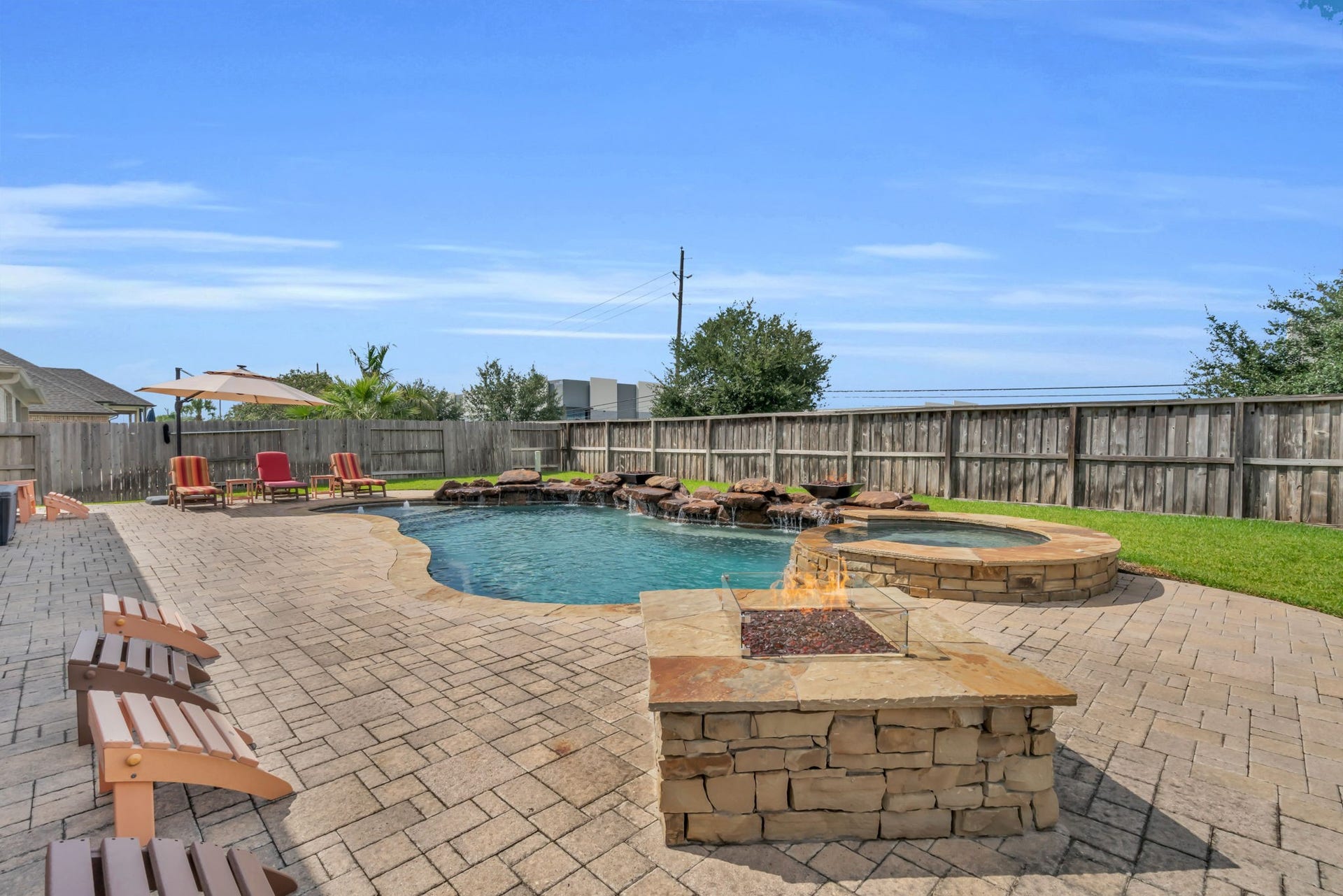 Cozy stone fire pit creates the perfect gathering spot beside the pool.