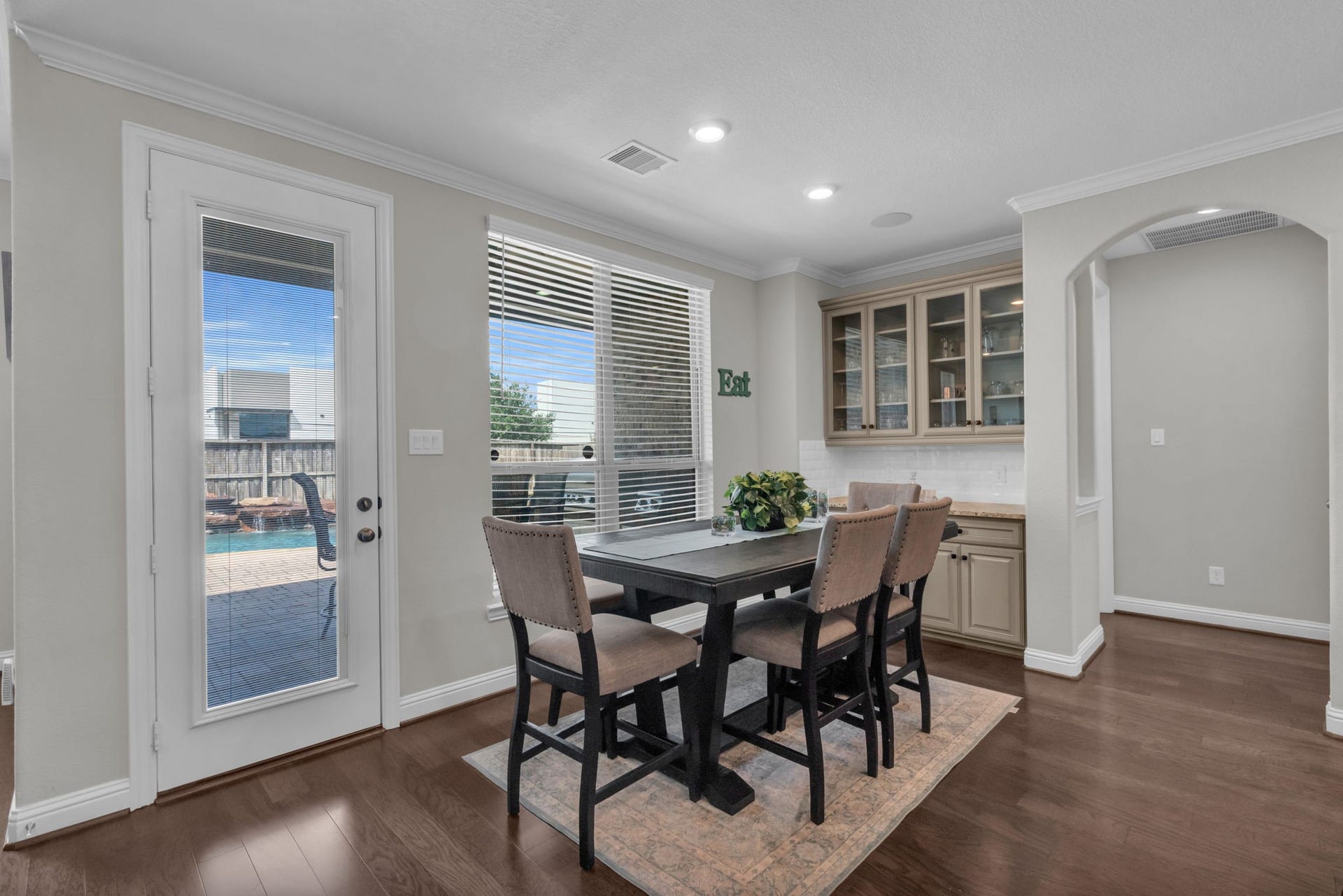 Charming breakfast nook offers built-in cabinetry, large windows, and direct backyard access.