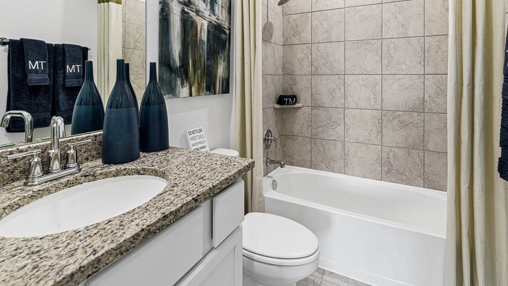 7334 Grand Mason Drive, Cypress, TX 77433 Bathroom 2 has a modern single vanity with silver fixtures, and granite counters, with a tub/shower combo.