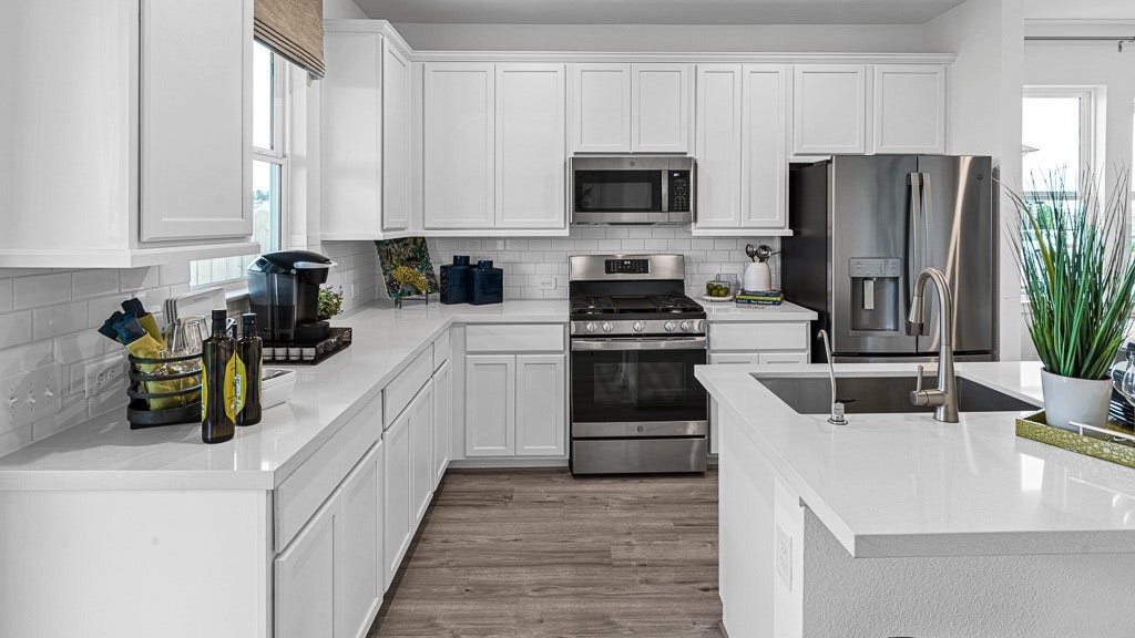 7334 Grand Mason Drive, Cypress, TX 77433 Crisp white modern cabinetry looks fabulous with white quartz counters, subway tile backsplash for a seamless look, while wood floors add warmth, character, and texture.