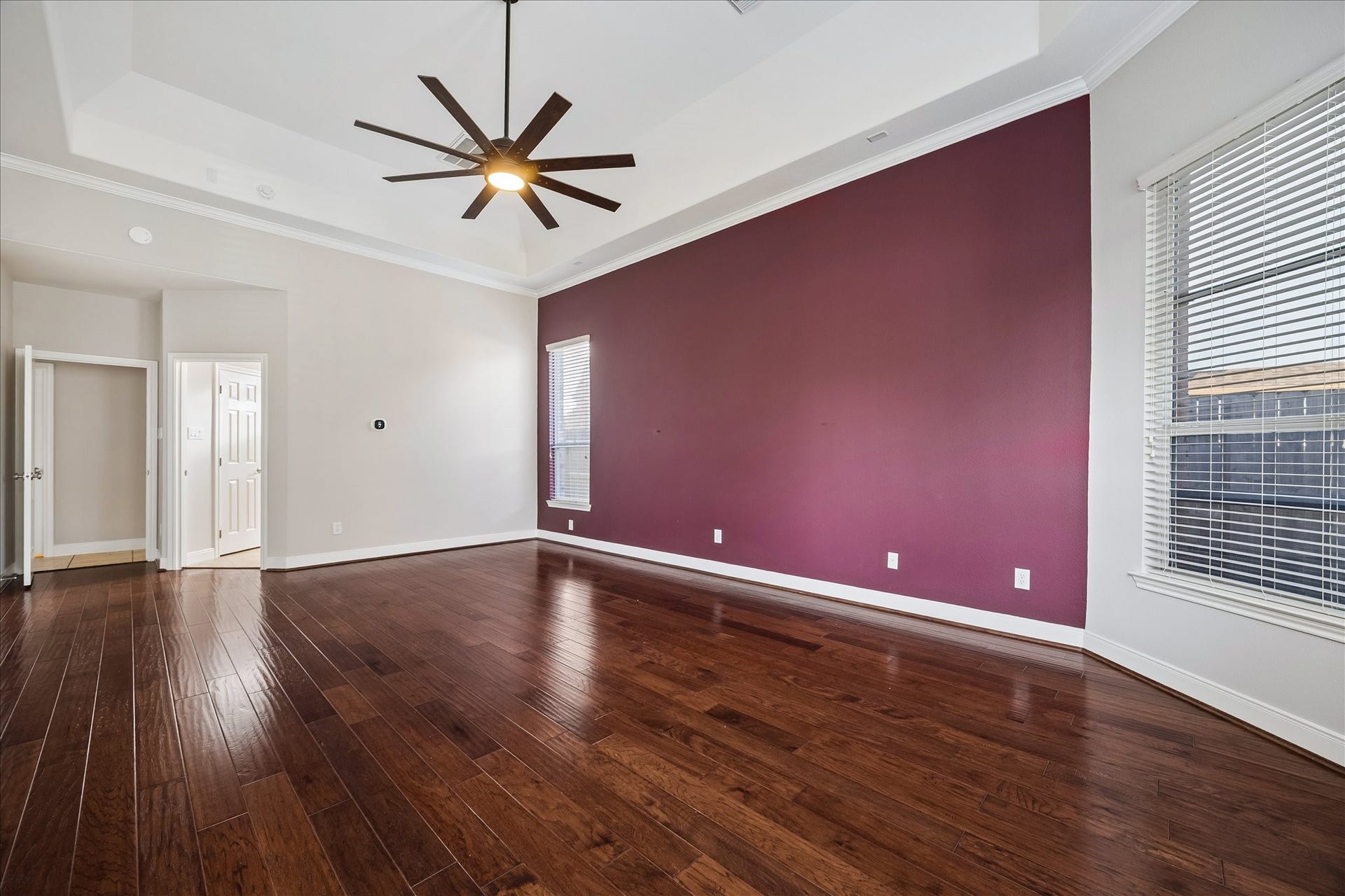 2902 Grand Mesa Pass, Missouri City, TX 77459 The spacious primary suite pairs rich wood flooring with fresh paint, a dramatic tray ceiling and bay windows that pull in natural light, while the walk-in closet and beautifully updated ensuite make daily routines feel a little more luxurious.