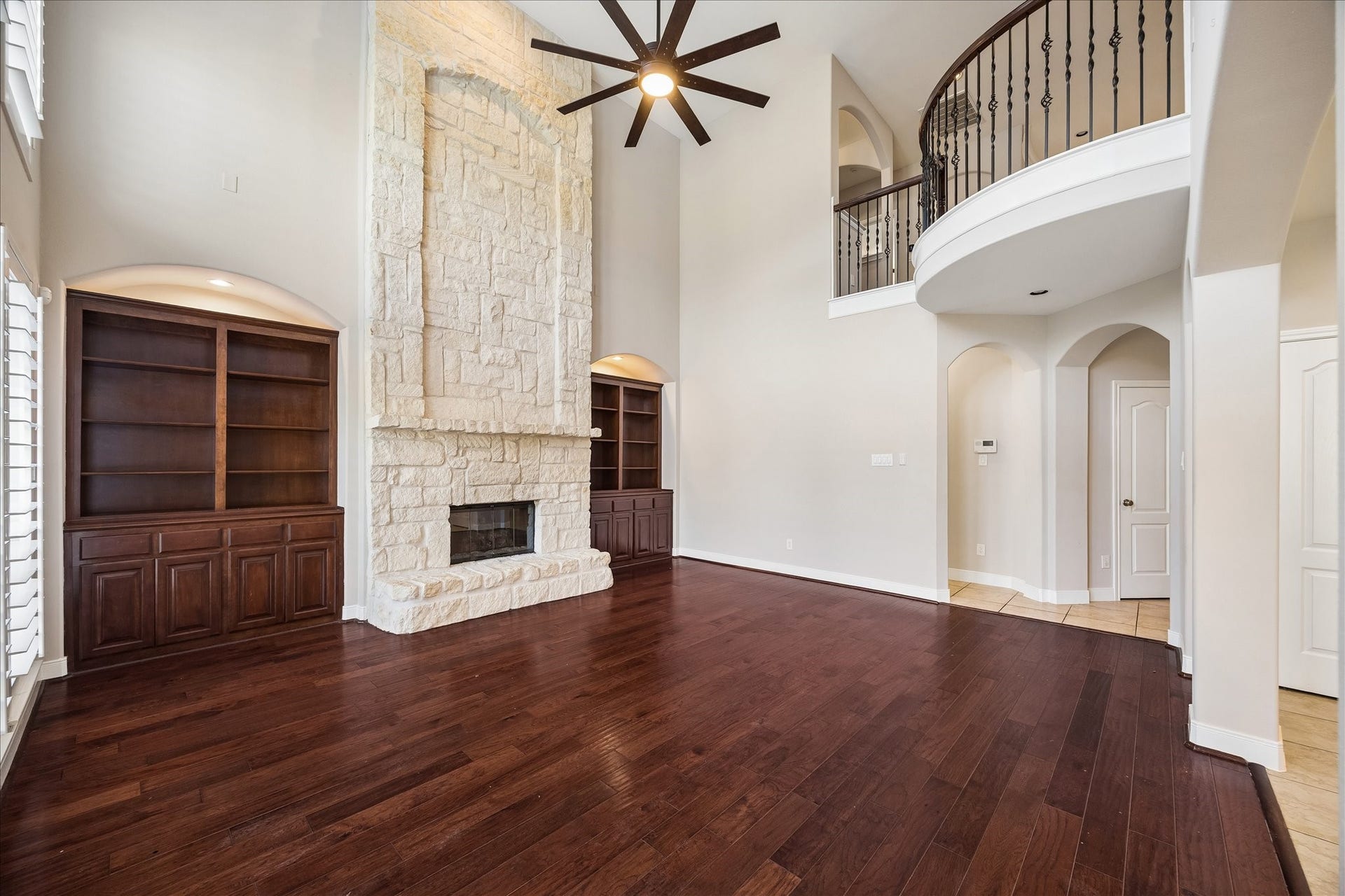 2902 Grand Mesa Pass, Missouri City, TX 77459 This family room is made to be lived in. Soaring ceilings, refinished wood flooring, fresh paint, custom built ins and a dramatic stone fireplace create a warm, welcoming space, while the open connection to the kitchen and casual dining area keeps everyone comfortably connected.