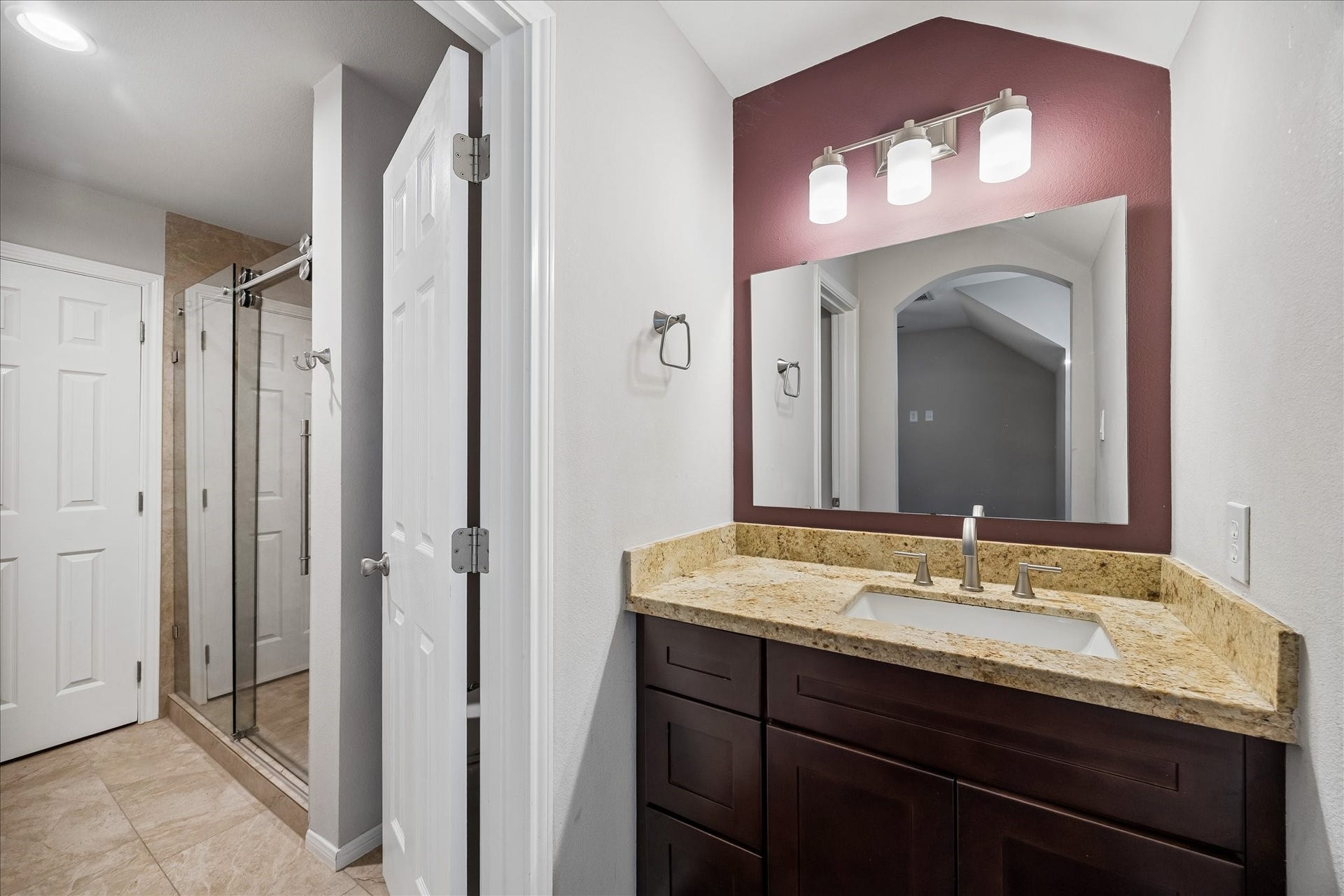2902 Grand Mesa Pass, Missouri City, TX 77459 Designed to connect two bedrooms with ease, this Hollywood bath gives everyone a little breathing room. A stylish vanity sits just outside the shared water closet, where a frameless glass walk-in shower adds a polished finish.