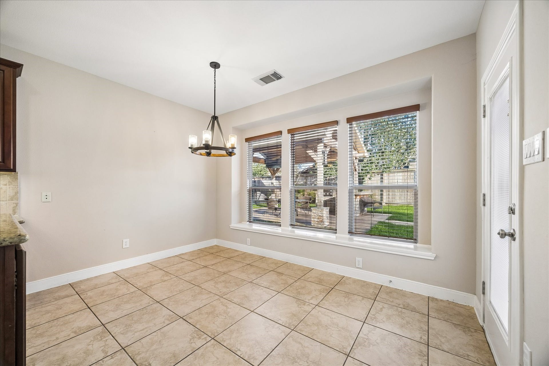 2902 Grand Mesa Pass, Missouri City, TX 77459 Fresh paint and tile flooring keep this casual dining area feeling bright and easy while a wall of windows with updated blinds and glass patio door with inset blinds bring in the backyard views.