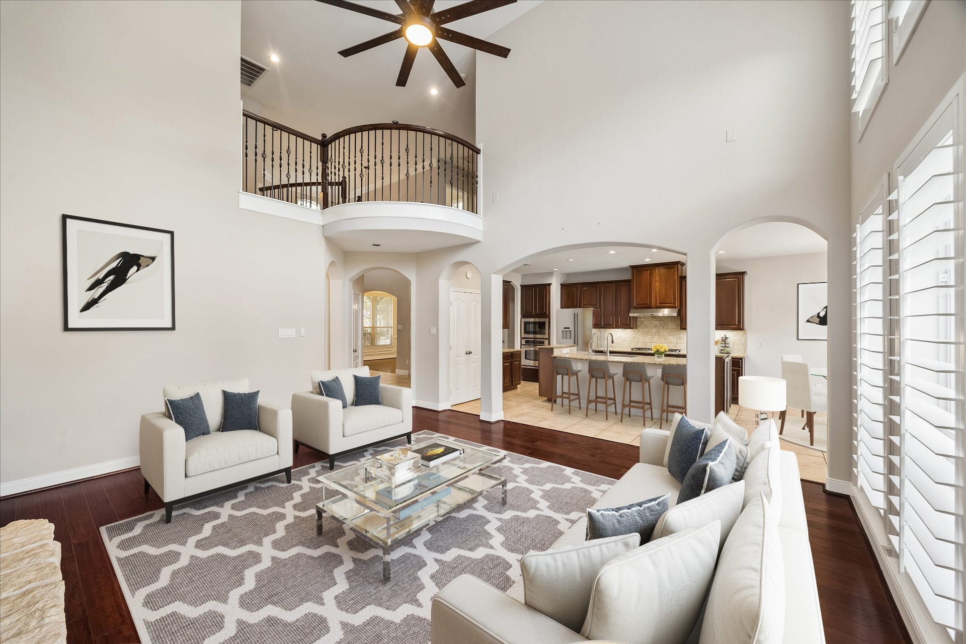 2902 Grand Mesa Pass, Missouri City, TX 77459 Fresh paint and refinished wood flooring give the family room a polished refresh, while arched openings connect easily to the kitchen and casual dining area. Look up and the Juliette balcony adds one more layer of character to this dramatic open space.