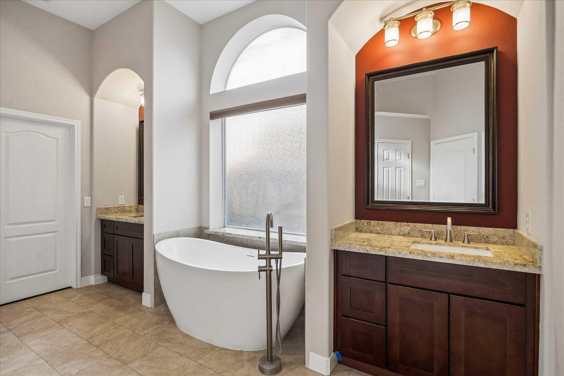 2902 Grand Mesa Pass, Missouri City, TX 77459 The renovated primary bath brings spa day home with a freestanding tub, walk-in shower, updated vanities, mirrors, lighting, shower and flooring. Tall windows and graceful arches add a little extra drama to the daily routine.