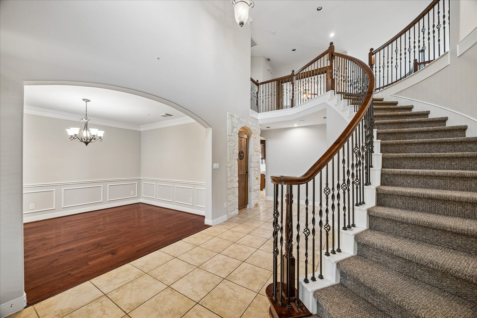 2902 Grand Mesa Pass, Missouri City, TX 77459 A grand sweeping staircase with iron balusters and rich wood railings sets the tone, while fresh interior paint keeps everything feeling light and polished. Formal dining and the wine grotto sit just off the entry, with the family room straight ahead. Its a comfortable setup for everyday living and easy entertaining.