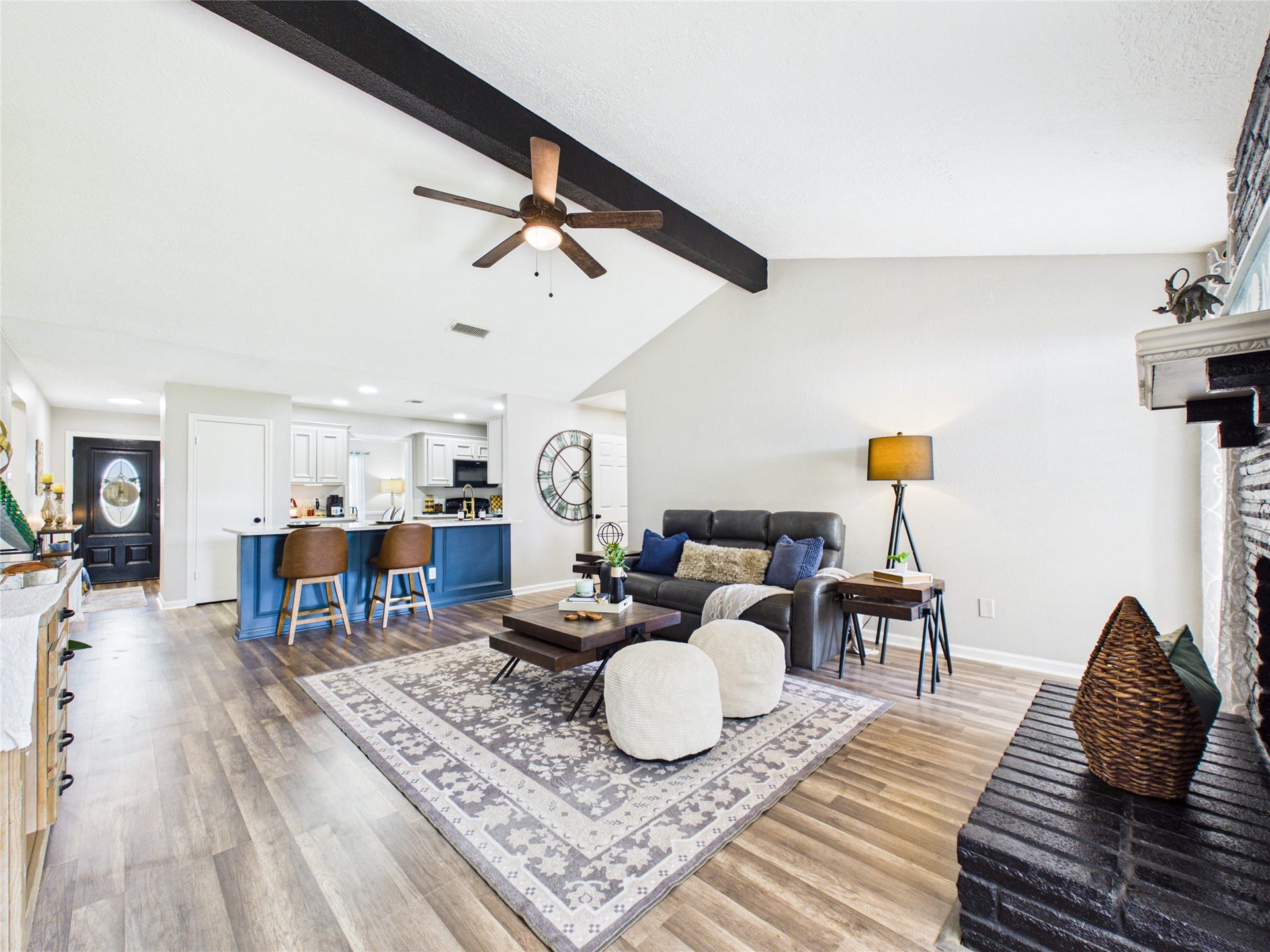 6209 Brookdale Drive, League City, TX 77573 Another view of the open-concept living area with elegant wood flooring, cozy seating, and a modern kitchen featuring a breakfast bar.