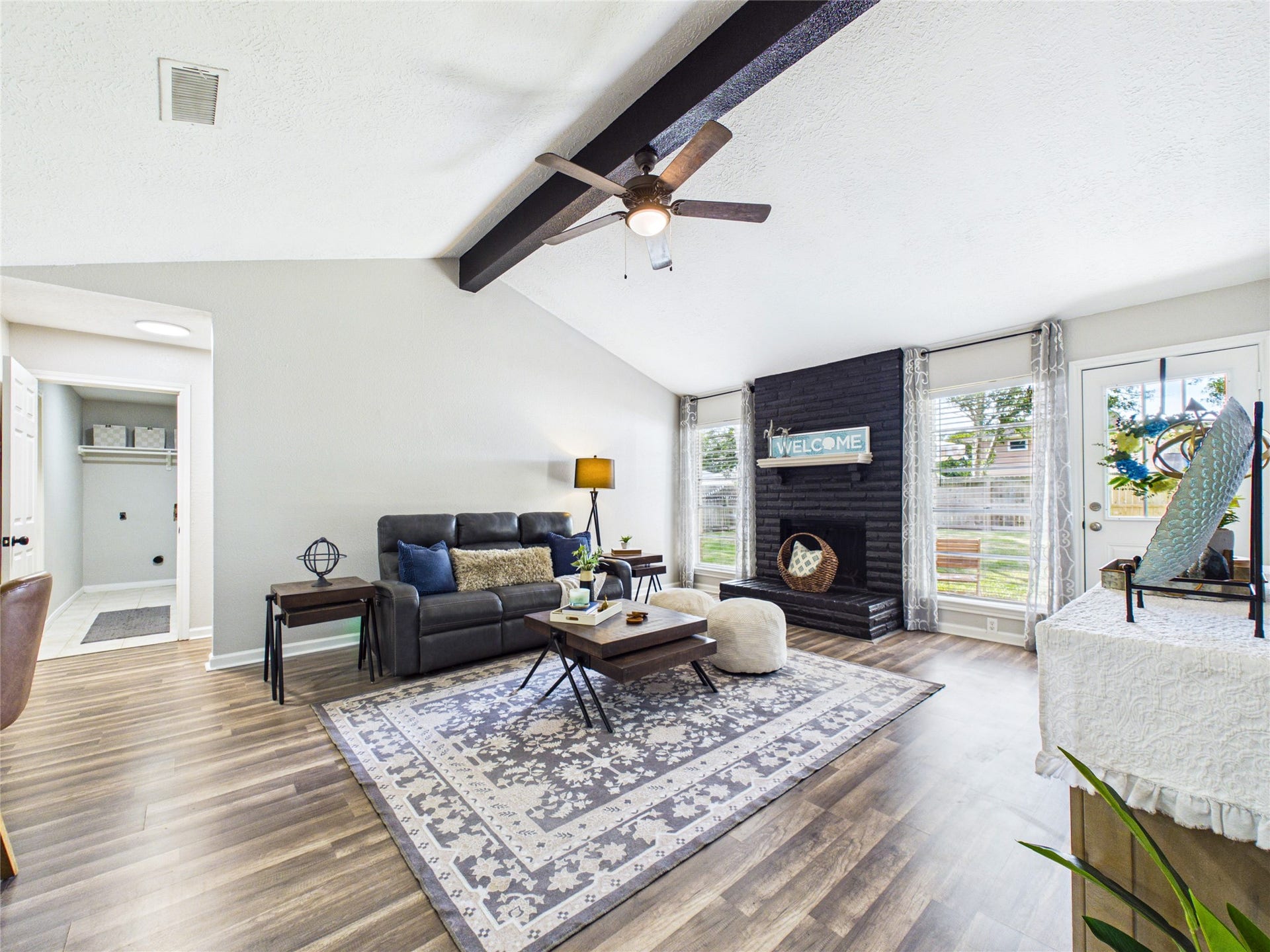 6209 Brookdale Drive, League City, TX 77573 Spacious living room with vaulted ceilings, featuring a cozy black brick fireplace and ample natural light from large windows.