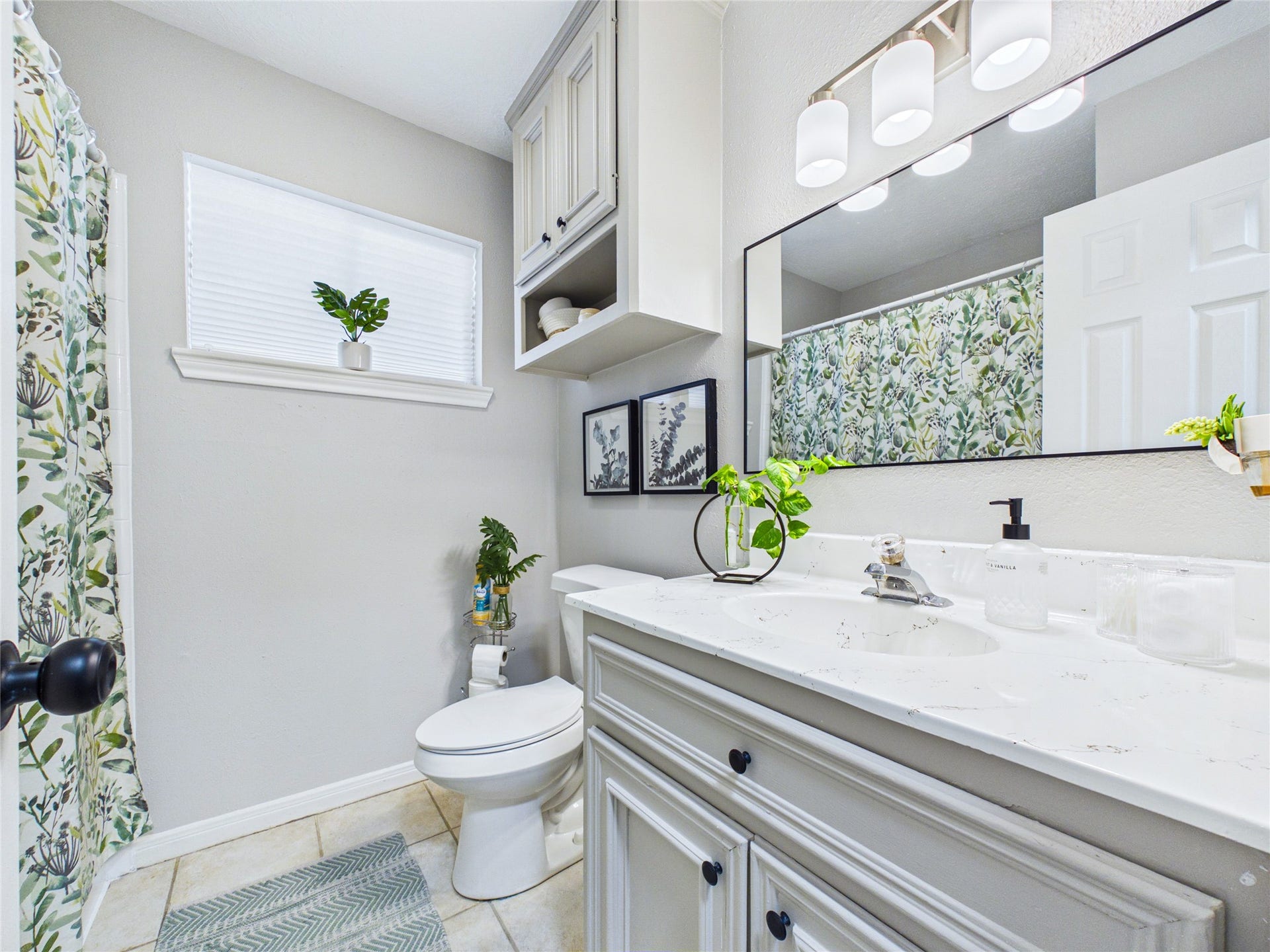 6209 Brookdale Drive, League City, TX 77573 Bright and inviting guest bathroom featuring a sleek vanity with ample storage, a large mirror, and stylish lighting.