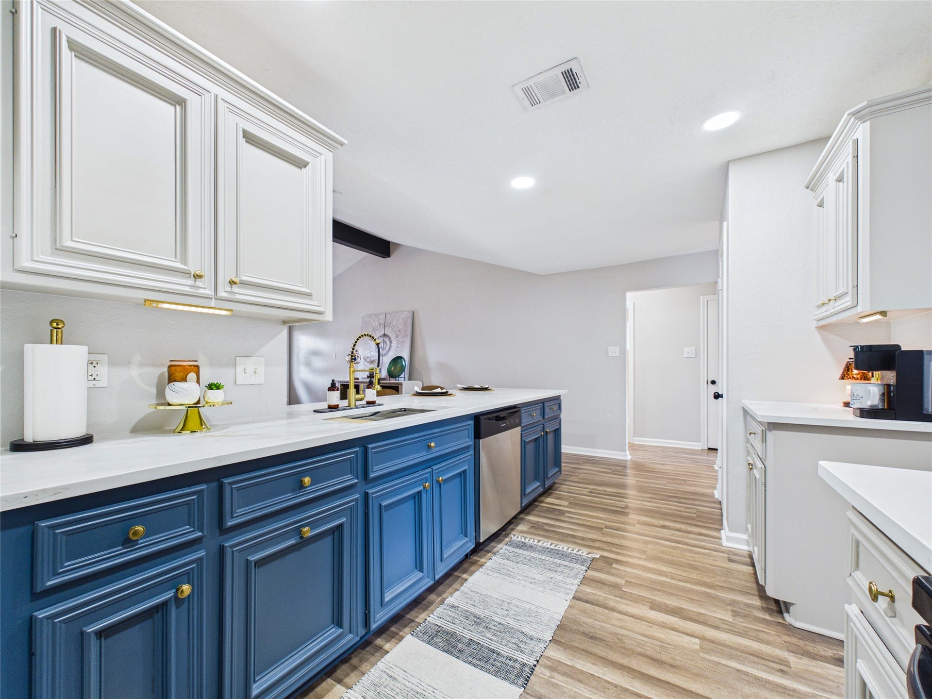 6209 Brookdale Drive, League City, TX 77573 Bright and spacious kitchen featuring elegant blue lower cabinets, sleek white quartz countertops, and stainless steel appliances.